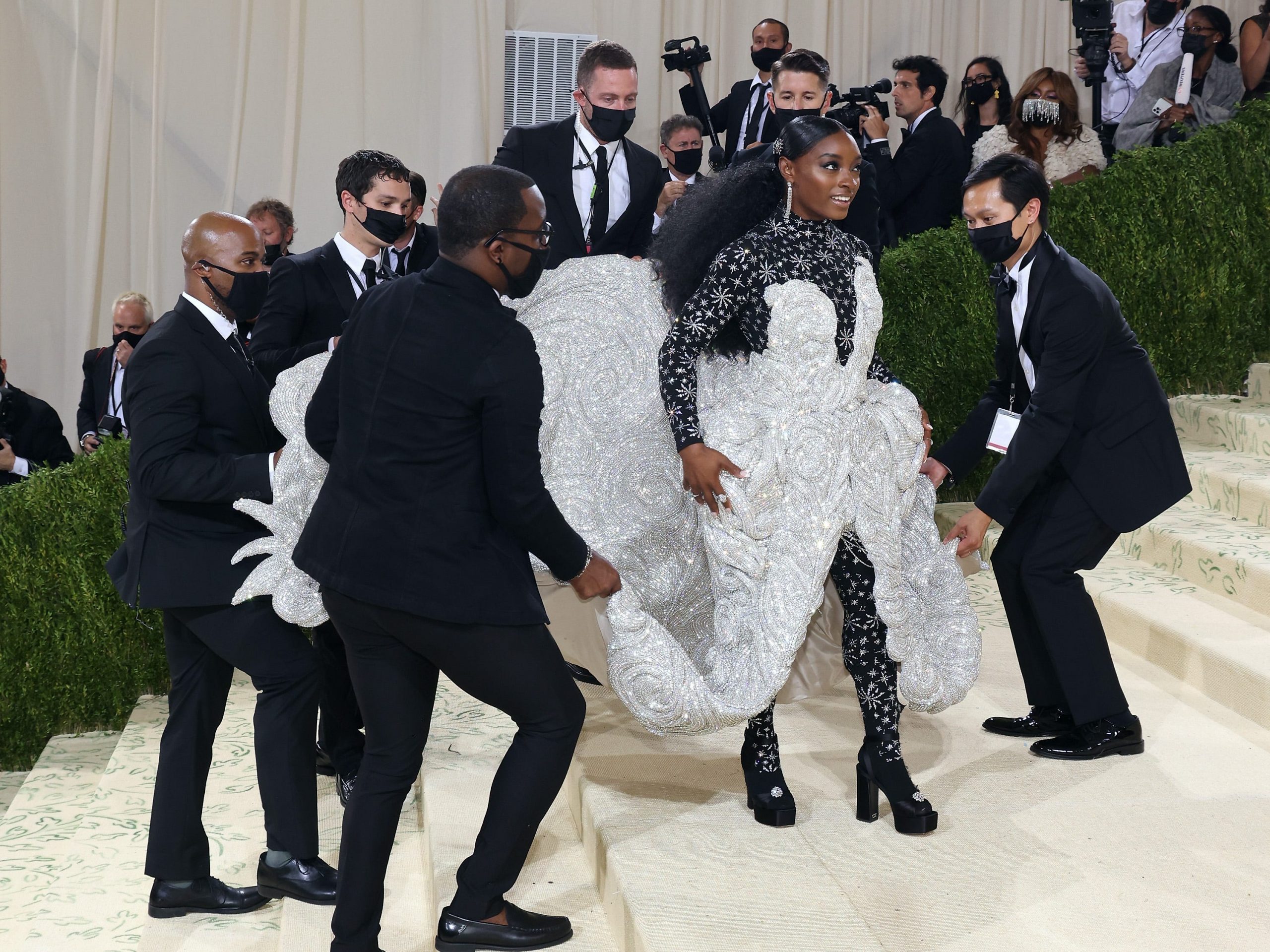 Simone Biles has the train of her dress carried at the Met Gala