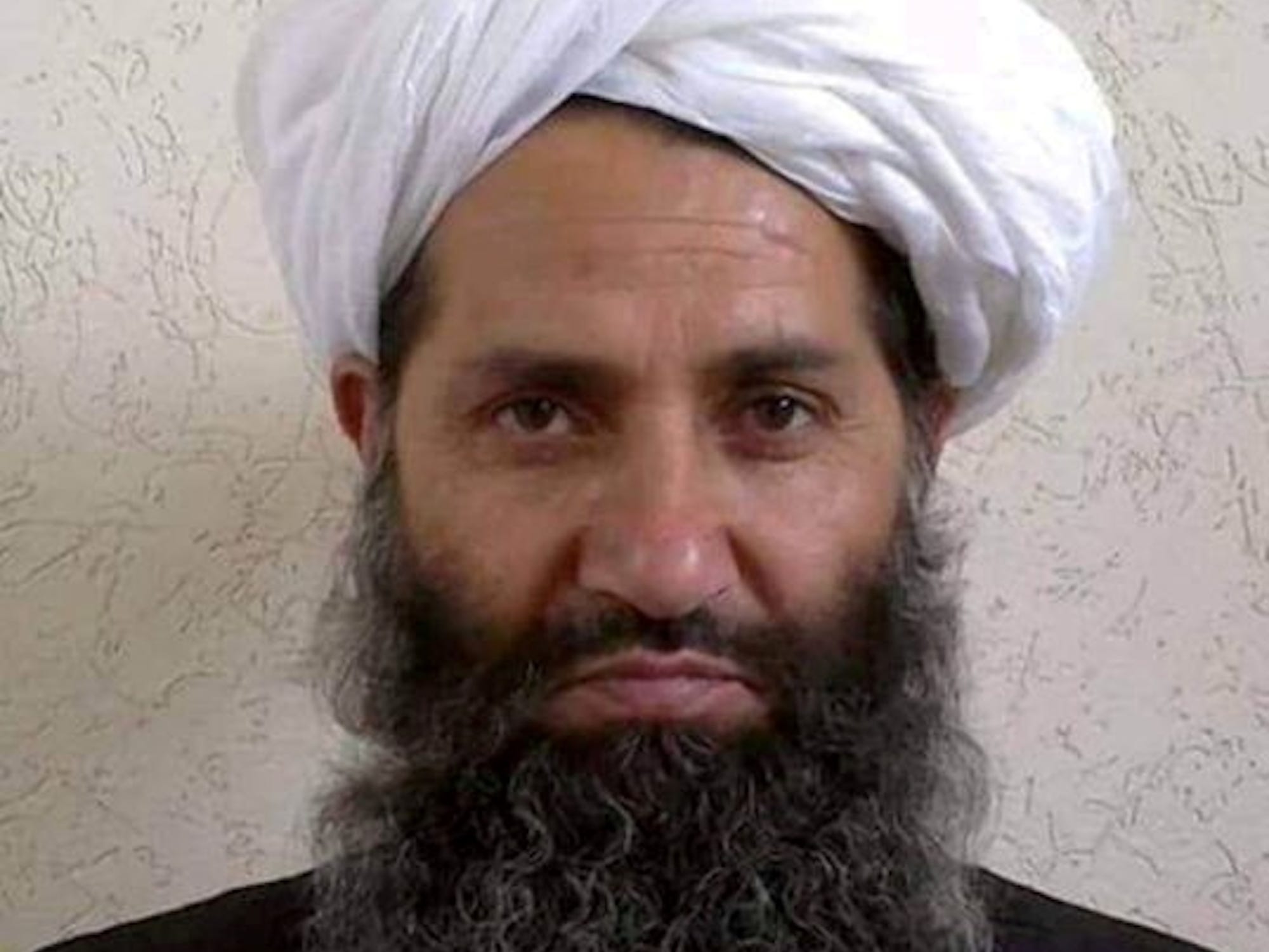 Haibatullah Akhundzada, in beard and turban, looks directly at the camera in a rare photo.