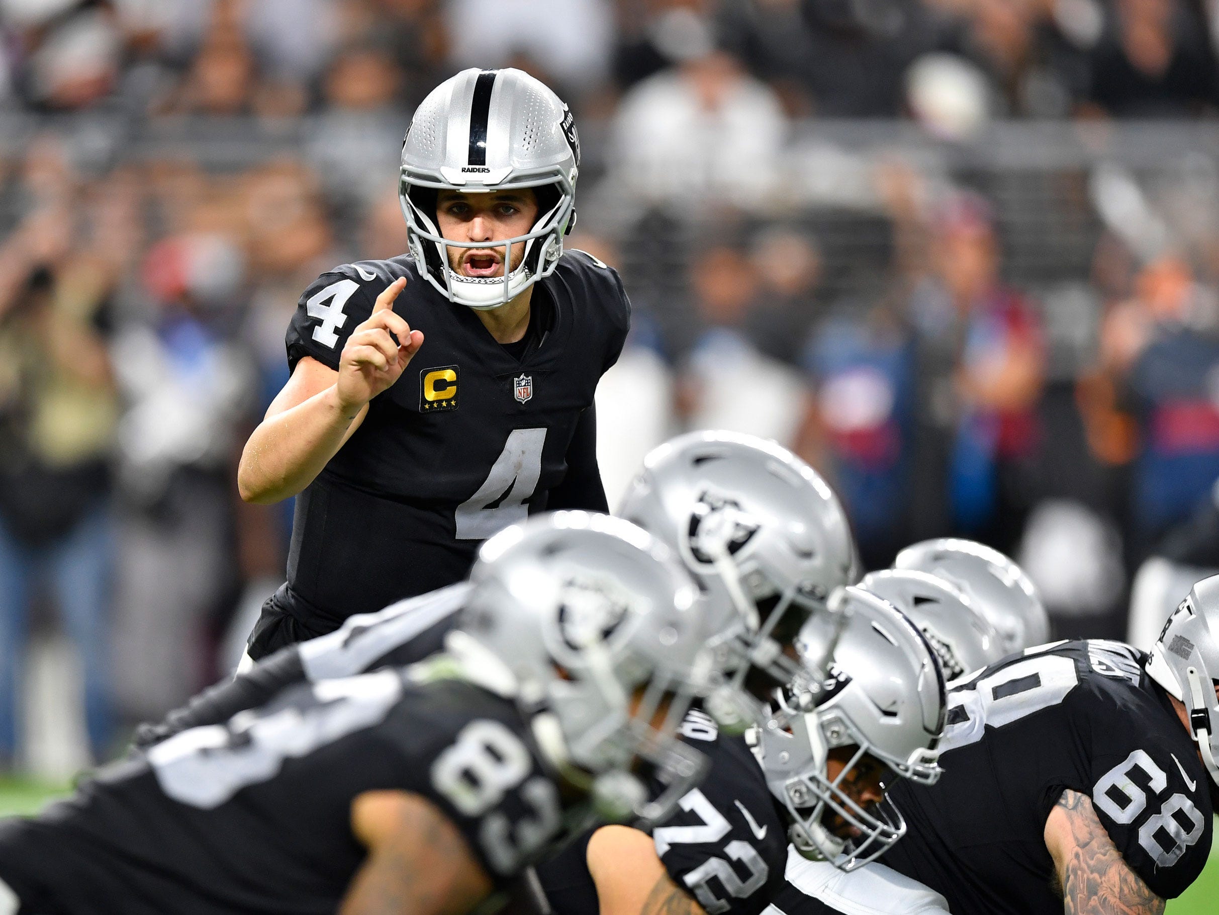Derek Carr calls out a signal at the line against the Baltimore Ravens.