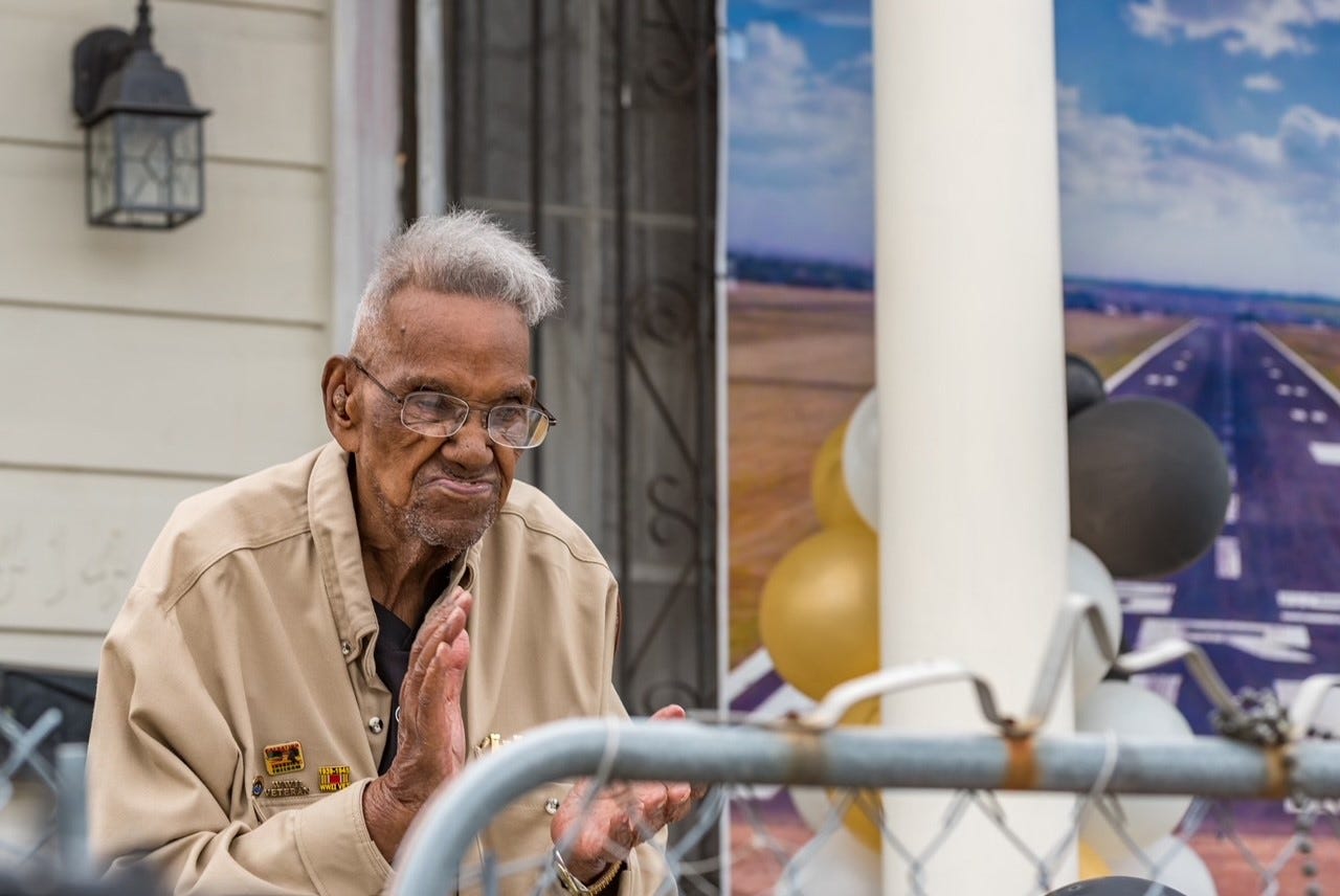World War II Veteran Lawrence Brooks claps as he celebrates his 112th birthday. Balloons can be seen in the background.