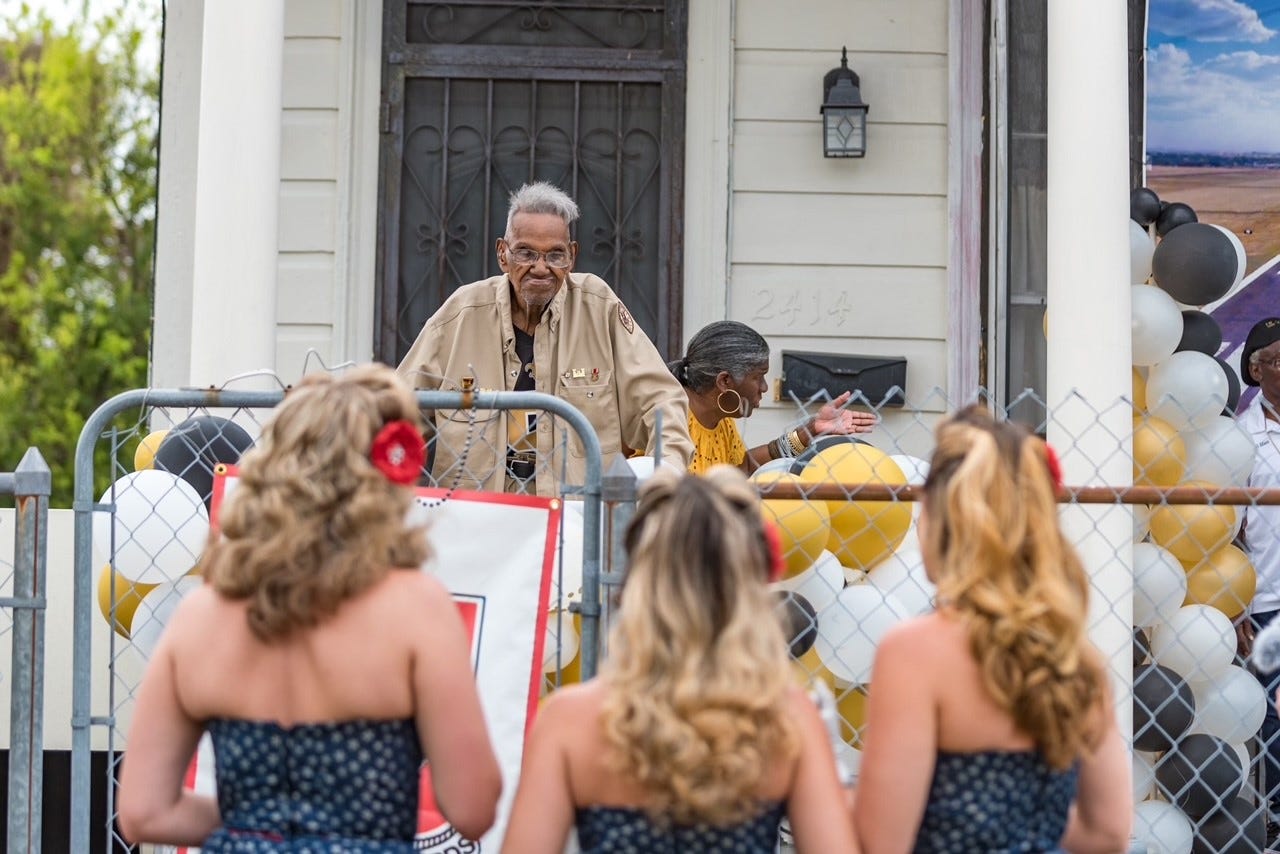 Lawrence Brooks stands on his porch as he is serenaded by The Victory Belles, the vocal trio of the National WWII Museum.