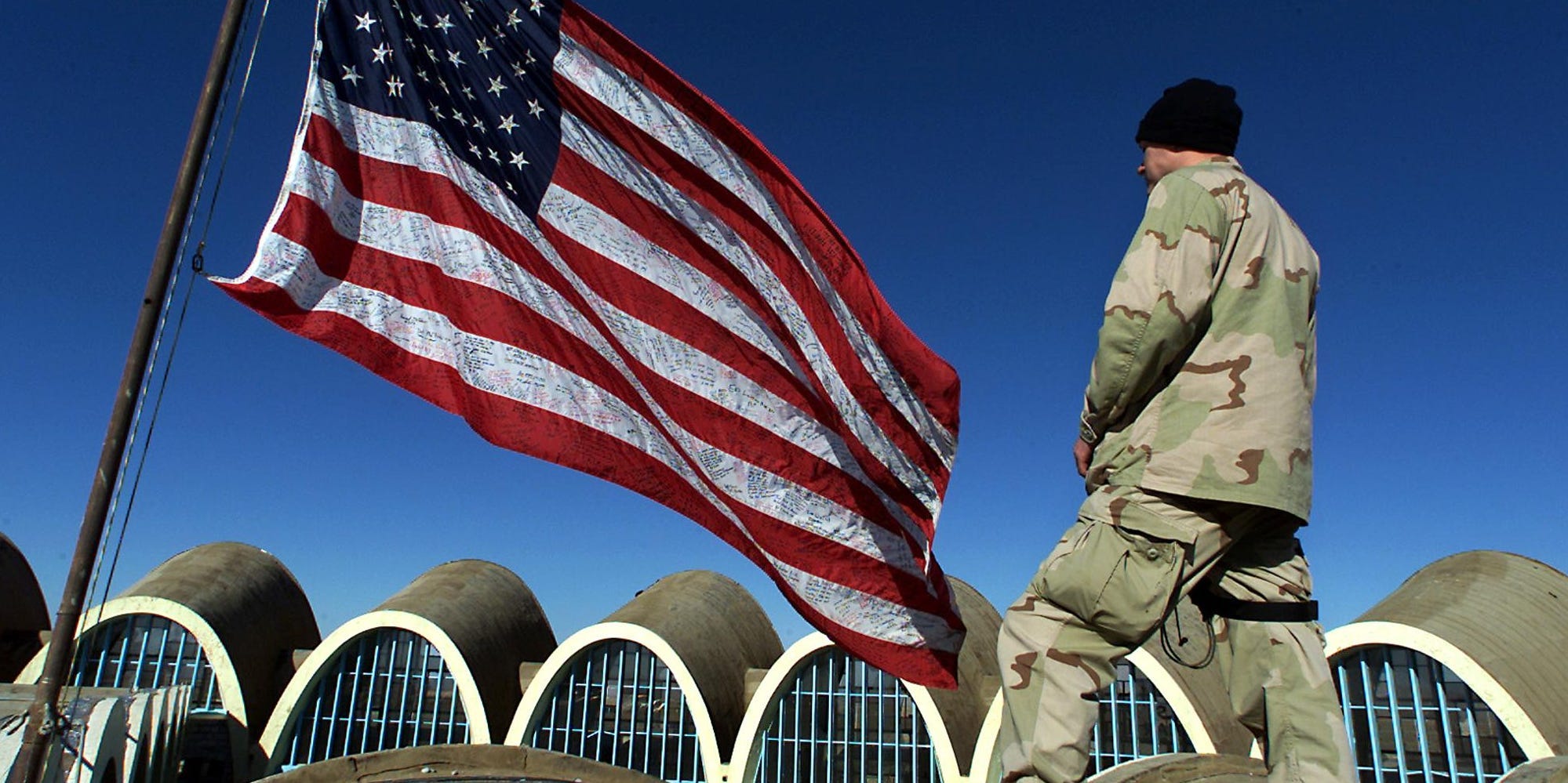 US soldier looks at American flag