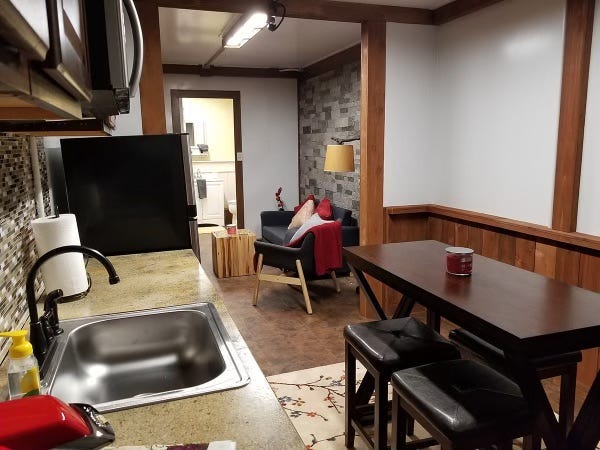 The kitchen of a bunker featuring a stainless sink, microwave, fridge, and dining area. Ron Hubbard/Atlas Survival Shelters