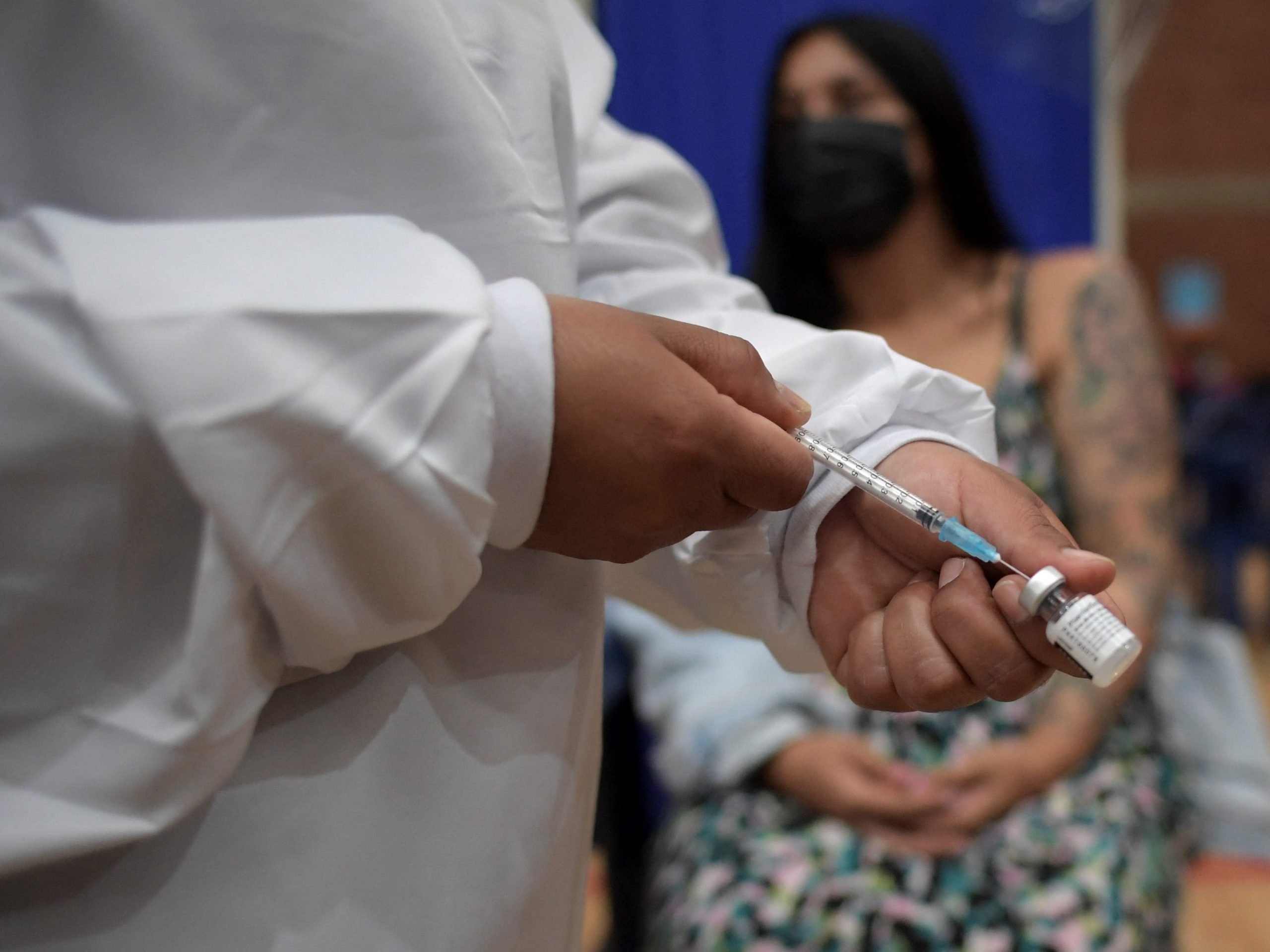 A health worker prepares to inoculate a pregnant woman with the Pfizer-BioNTech vaccine against COVID-19 at a vaccination center in Bogota.