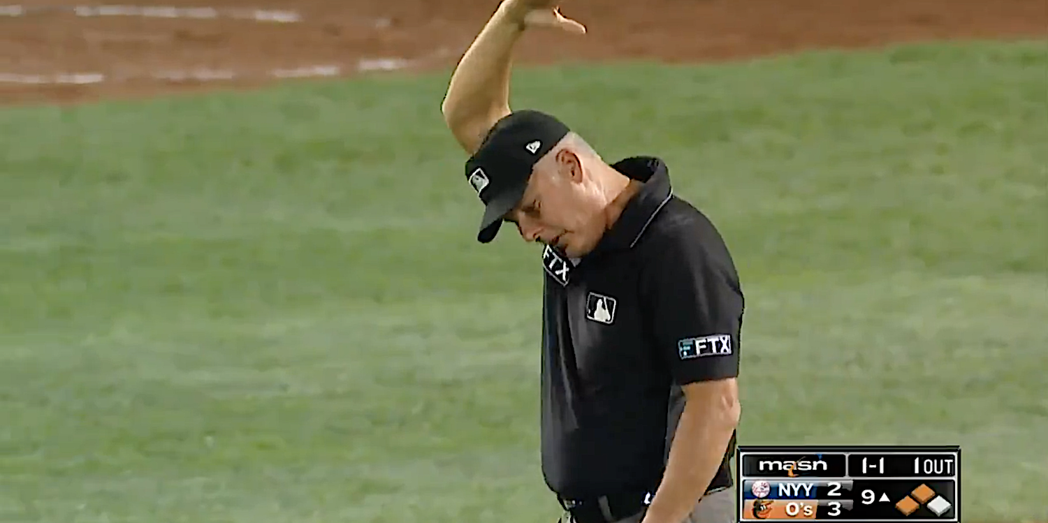 Umpire Tim Timmons waves the Orioles ground crew off the field.