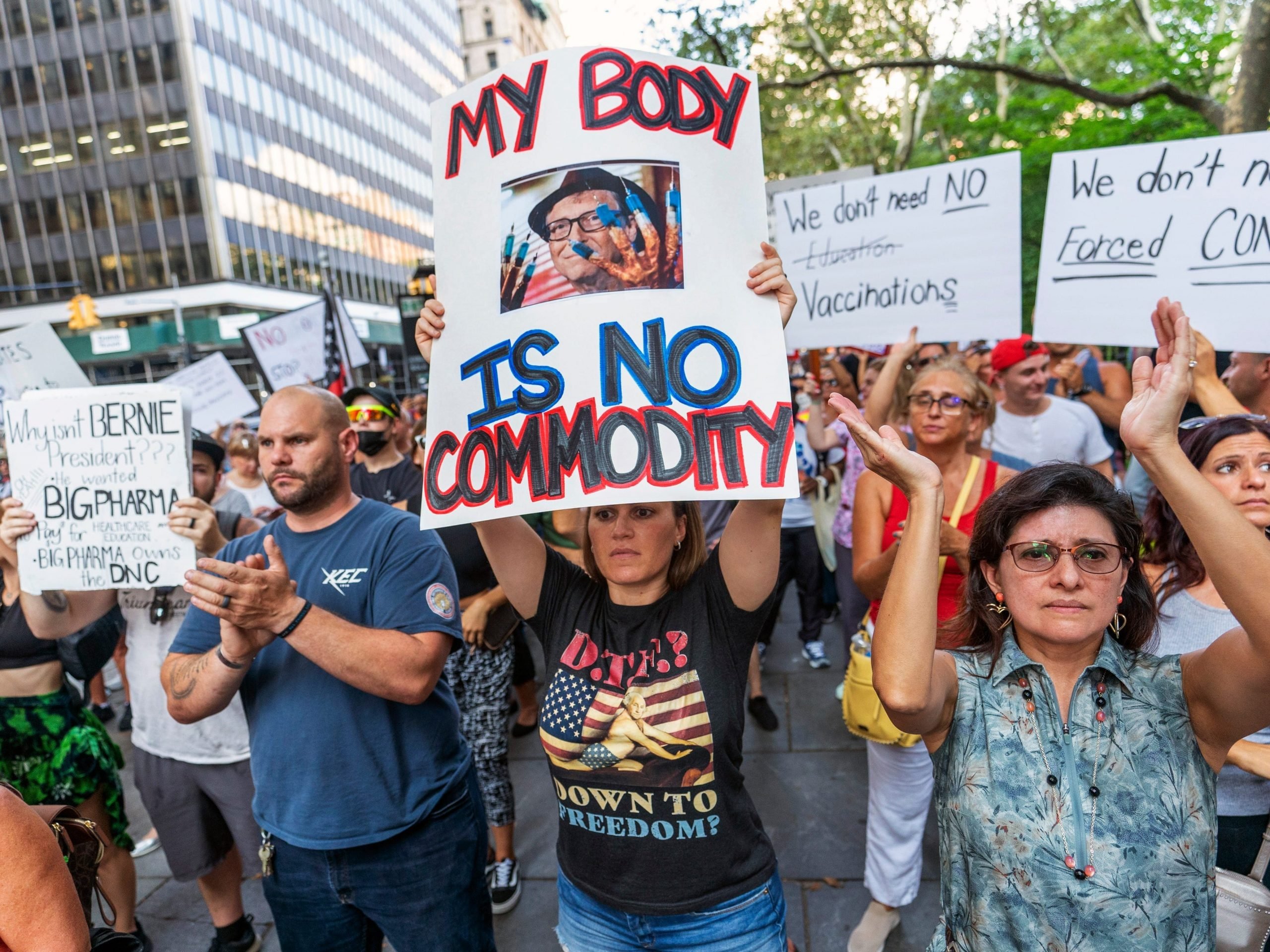 A crowd of people hold up signs. A woman in the middle holds a sign that says "My body is no commodity."