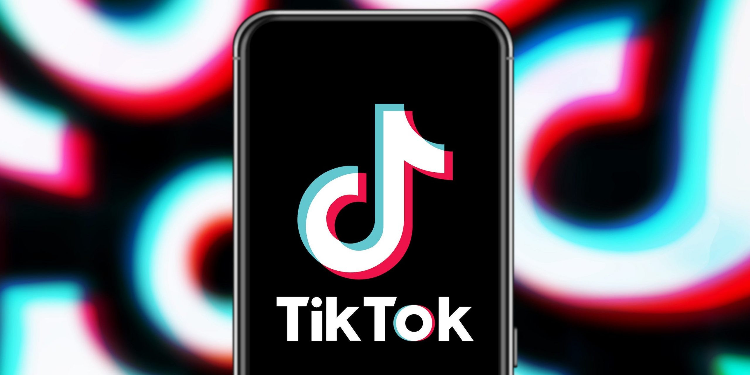 An iPhone displaying the TikTok logo. The background is made up of large TikTok logos.