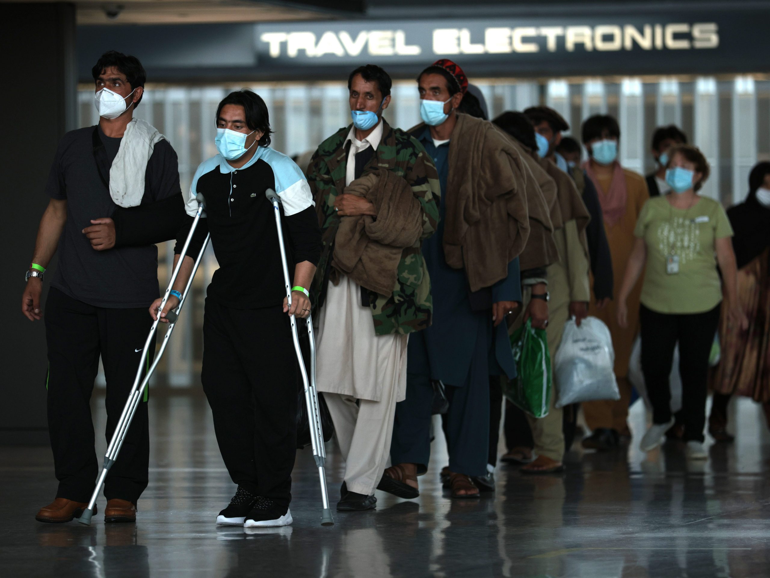 Refugees are led through the departure terminal to a bus that will take them from the Dulles International Airport to a refugee processing center after being evacuated from Kabul following the Taliban takeover of Afghanistan on August 31, 2021 in Dulles, Virginia. The Department of Defense announced yesterday that the U.S. military had completed its withdrawal from Afghanistan, ending 20 years of war.