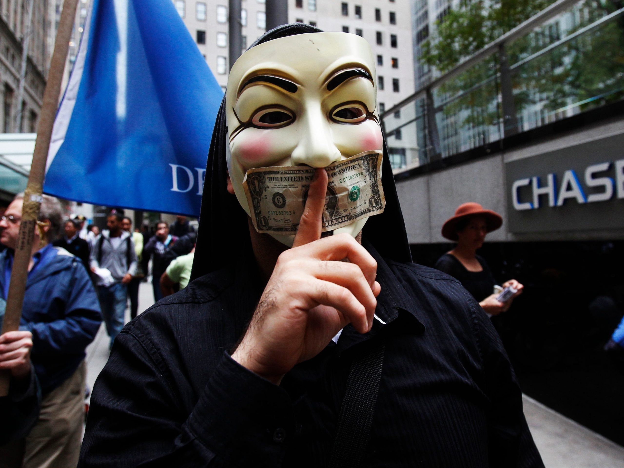 A man wearing a Guy Fawkes mask stands outside of a Chase Bank in Manhattan during the Occupy Wall Street protest.