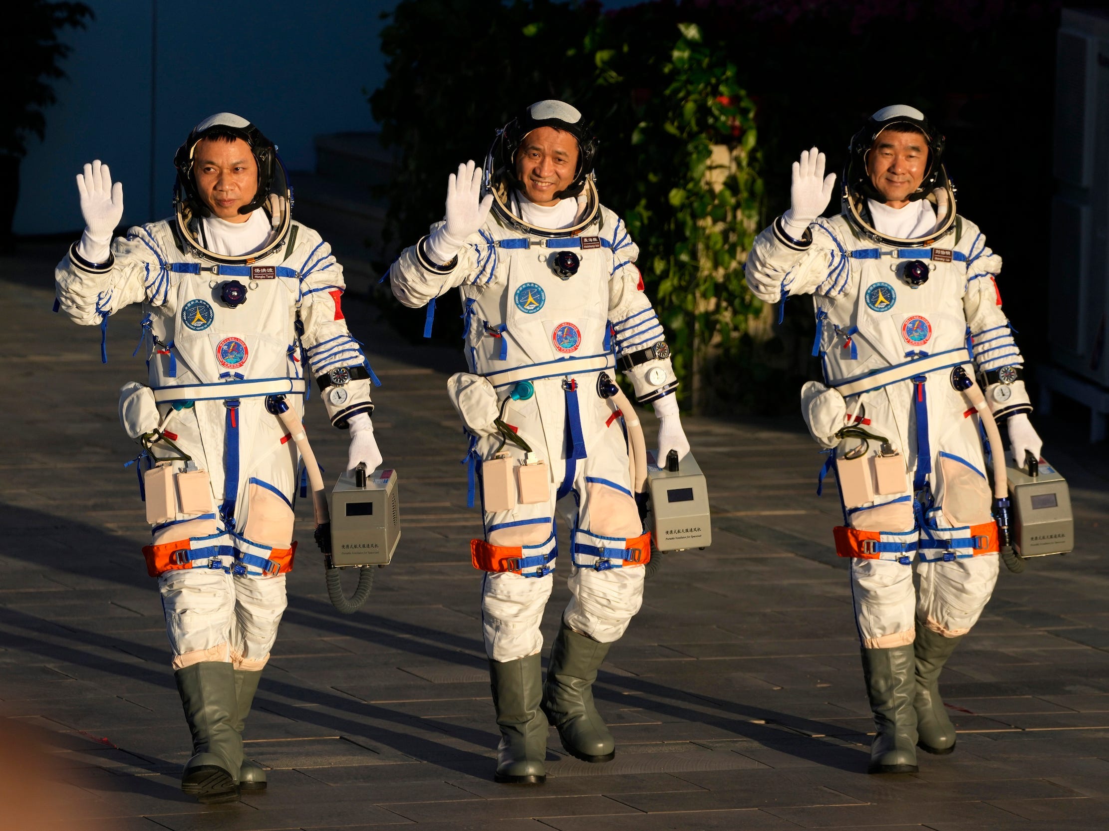 chinese astronauts three taikonauts in spacesuits wave