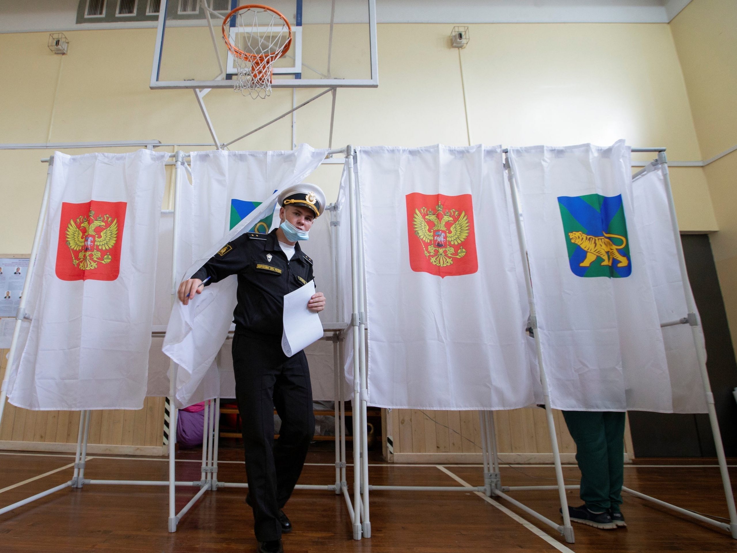 A Russian service member walks out of a voting booth during the 2021 Russian parliamentary election.