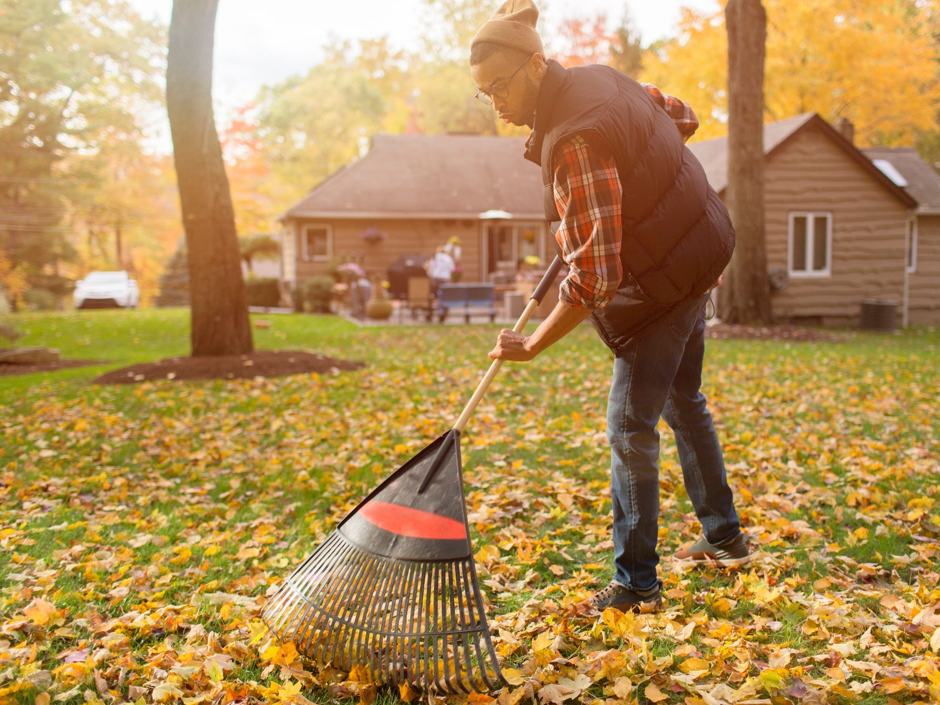 A man raking leaves in his backyard