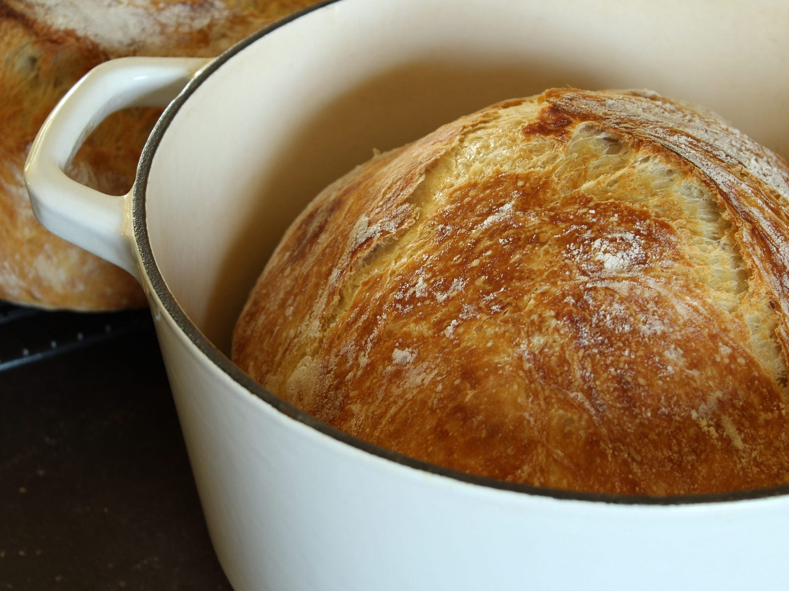 A freshly baked loaf of bread in a Dutch oven