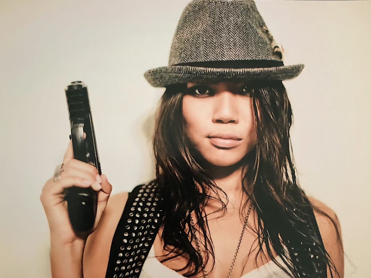 Actress Jessica Joan holds a handgun. She's written a book about her time in the NXIVM sex cult.