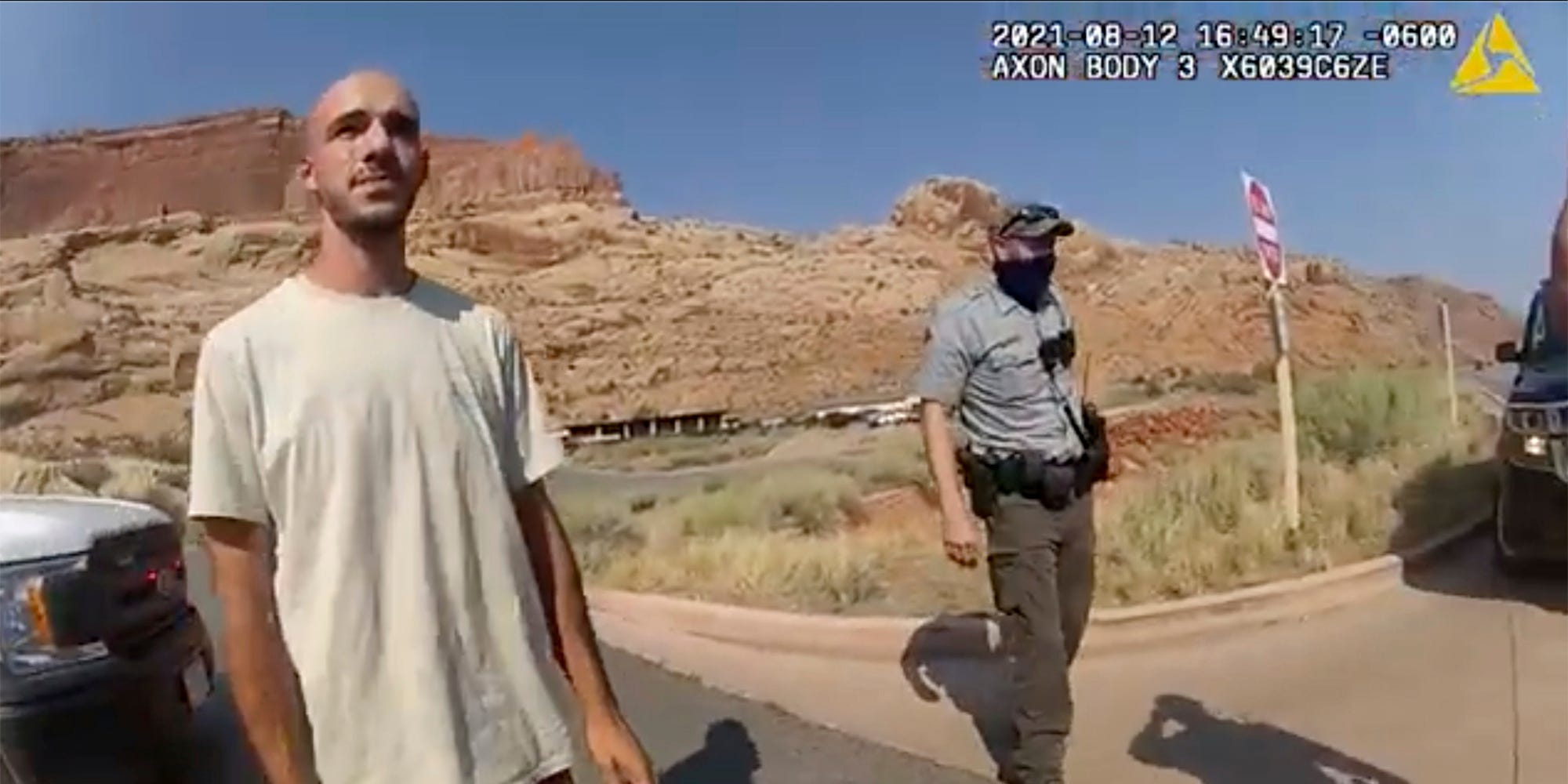 Brian Laundrie in the desert with a cop behind him