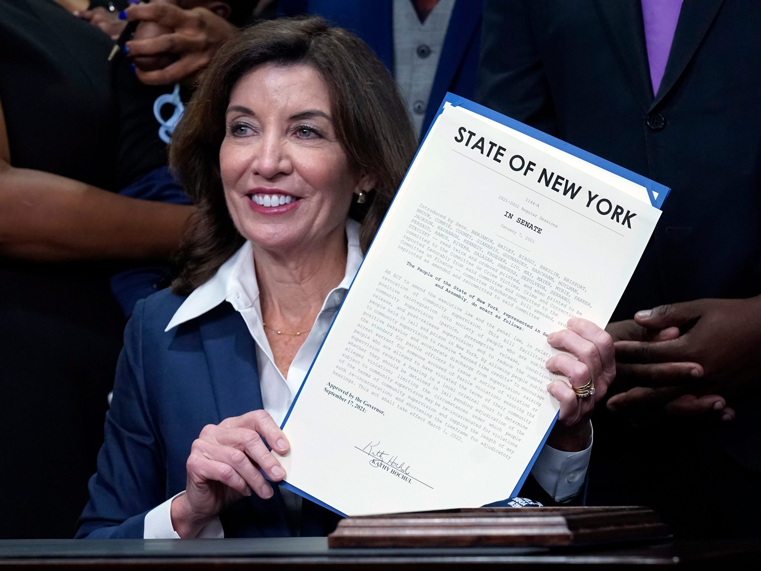 New York Gov. Kathy Hochul holds the "Less is More" law she signed, during ceremonies in the her office, in New York, Friday, Sept. 17, 2021.