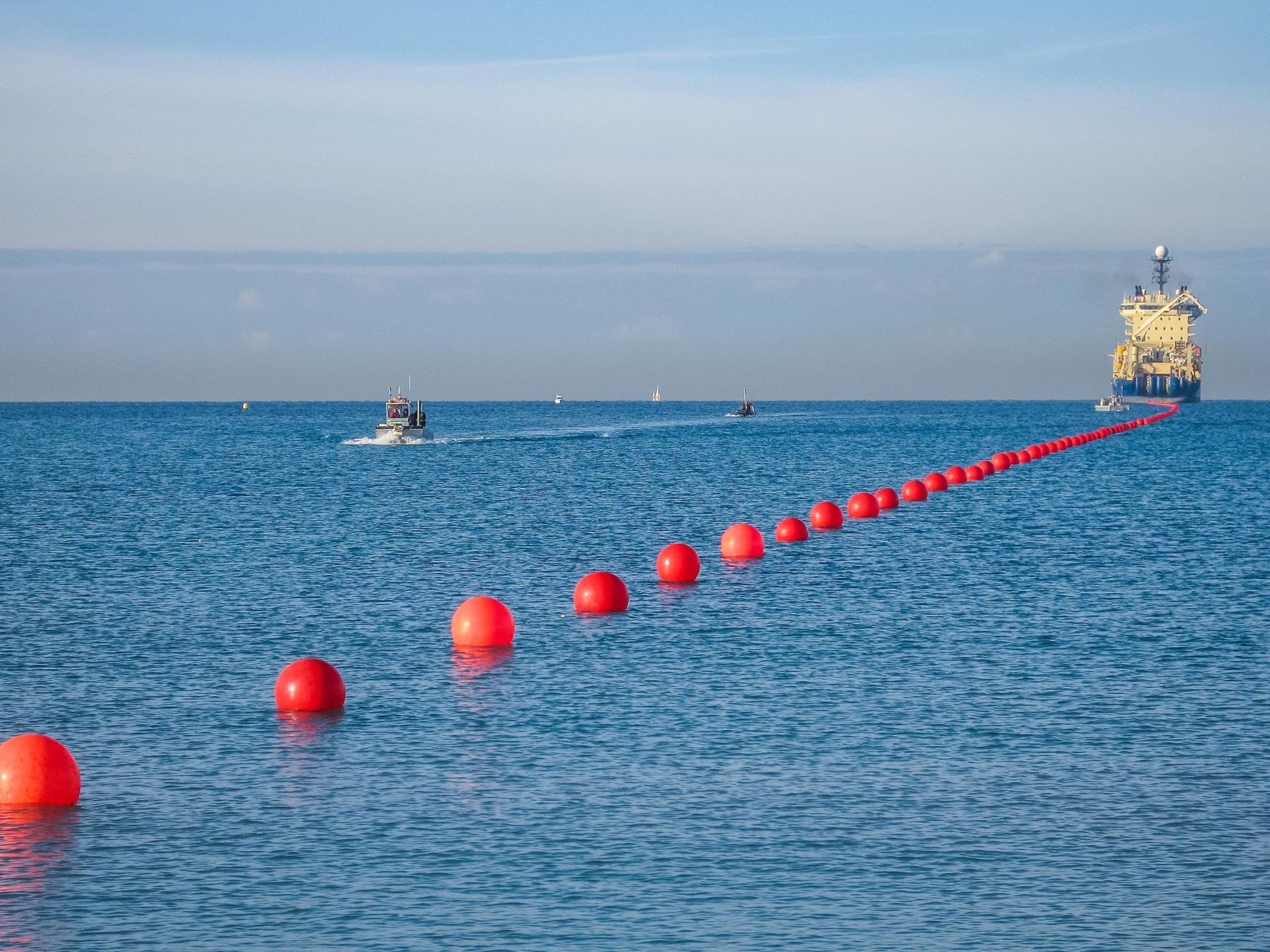 A line of buoys helps float a subsea internet cable as it&#39;s landed on the shore.
