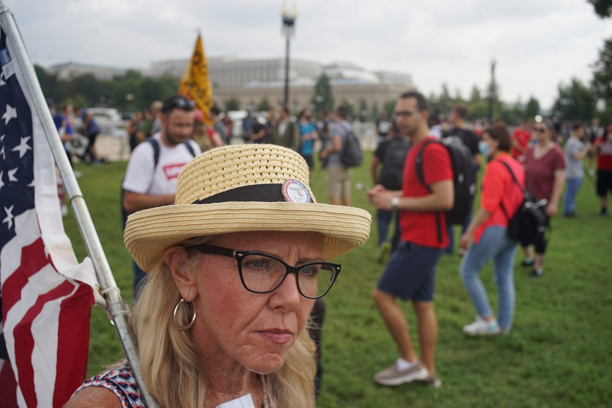 A women in a hat holds an American flag