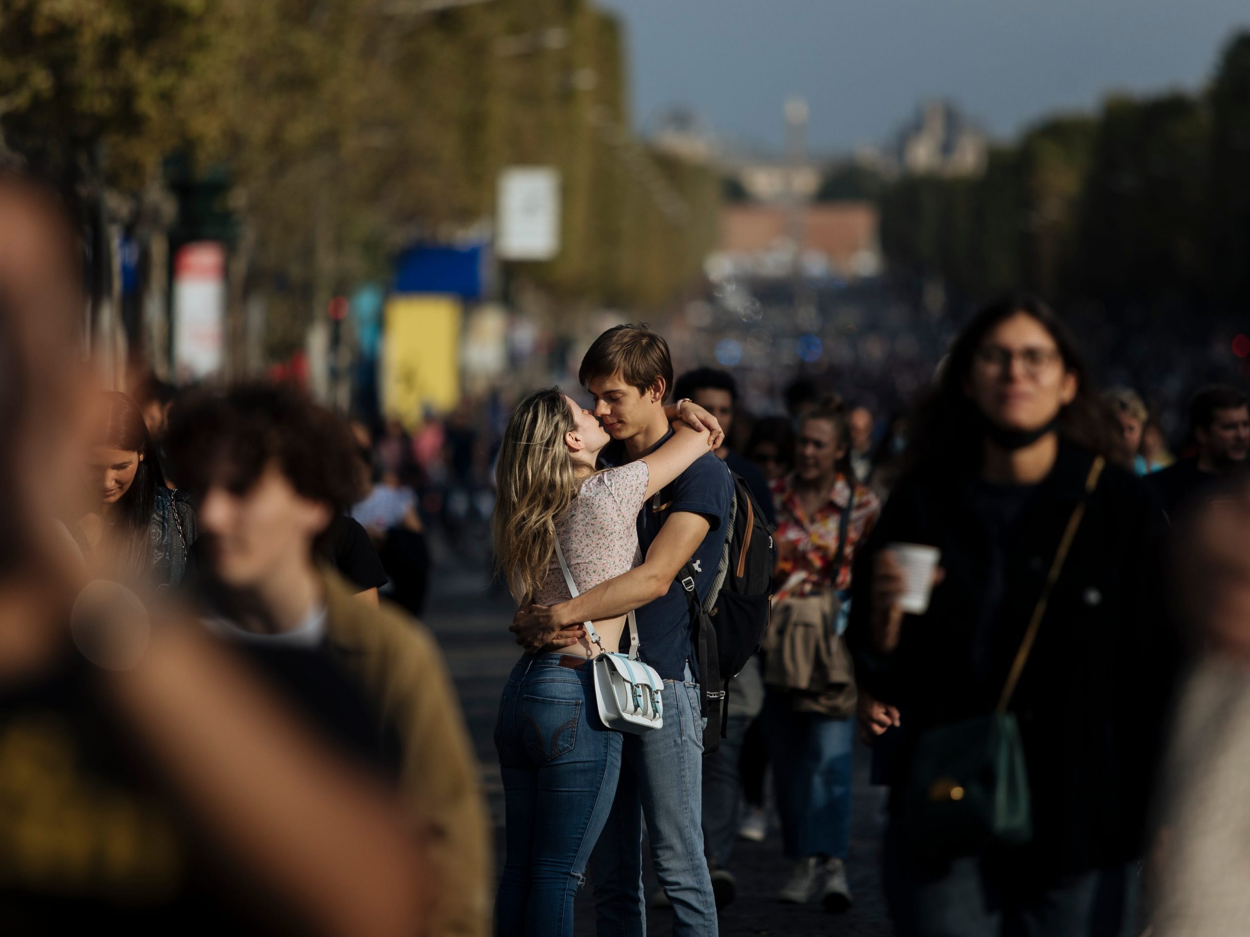 A couple kiss on the Champs Elysees Avenue, Paris, during the "day without cars", with the Arc de Triomphe in the background, Sunday, Sept. 19, 2021.