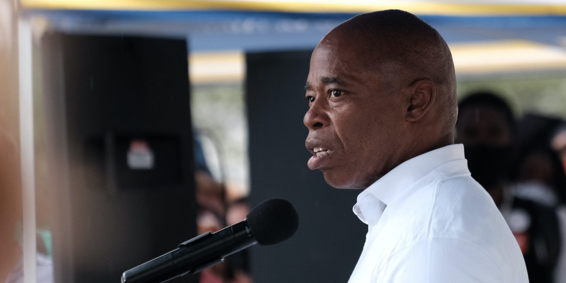 New York City Democratic mayoral nominee Eric Adams speaks in profile at a microphone.