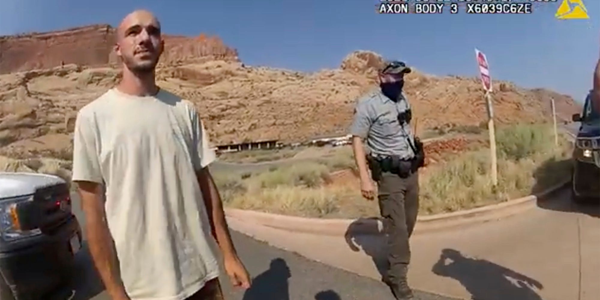 Brian Laundrie in the desert with a cop behind him