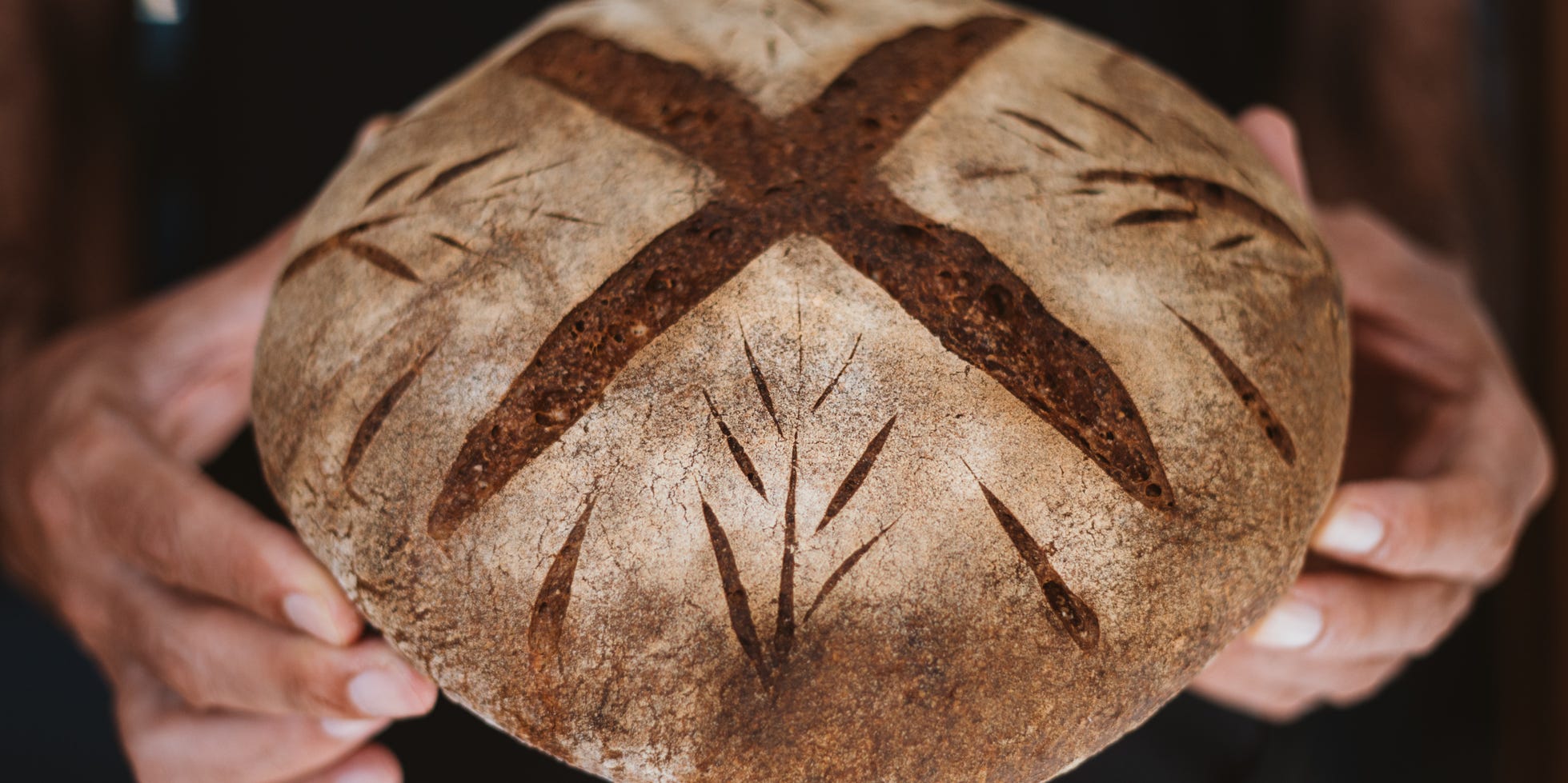 Someone holding a loaf of sourdough.