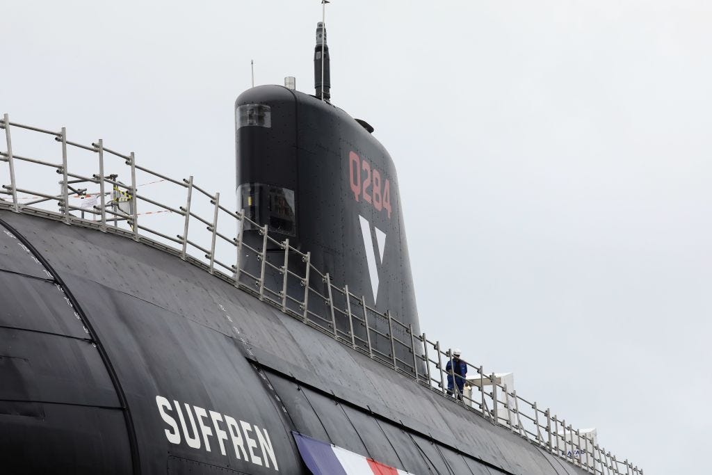 A Naval Group staff member stands atop the new nuclear submarine called "Suffren" in the Naval Group shipyard in Cherbourg, north-western France on July 12, 2019, ahead of its unveiling ceremony.