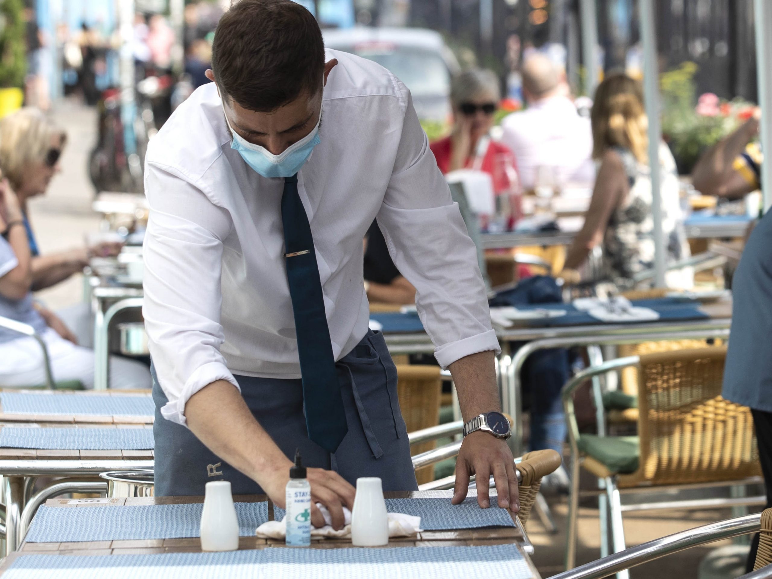 A waiter sets a table outside Hugos restaurant on Merrion Row in Dublin, where they will reopen for indoor dining on Thursday July 29.