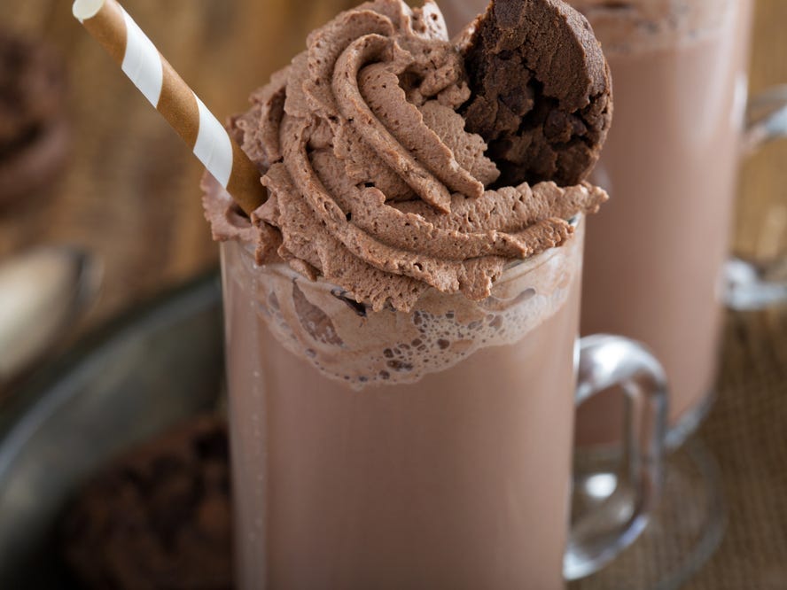 A chocolate milkshake topped with chocolate whipped cream.