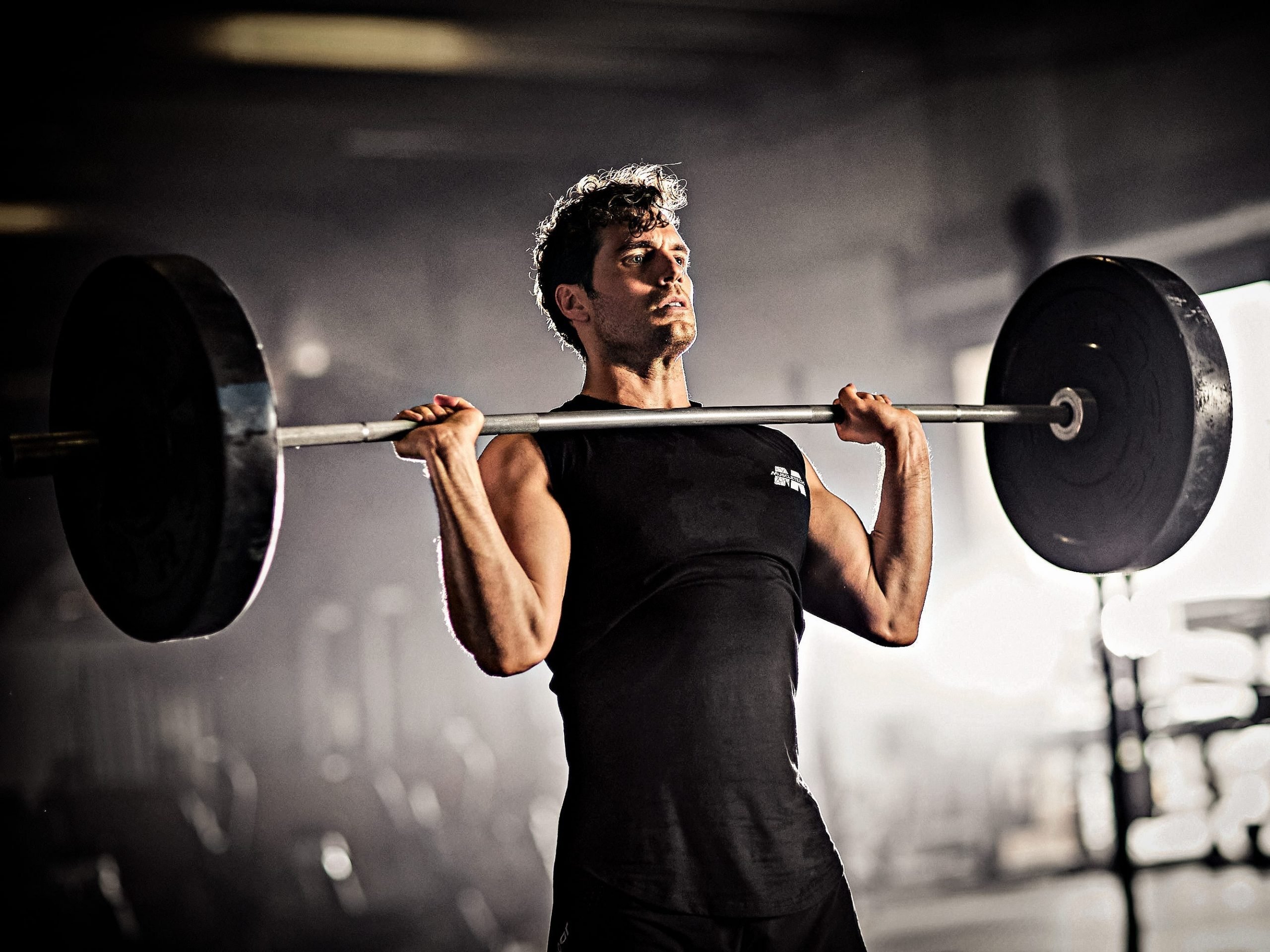 Henry Cavill holding a barbell.