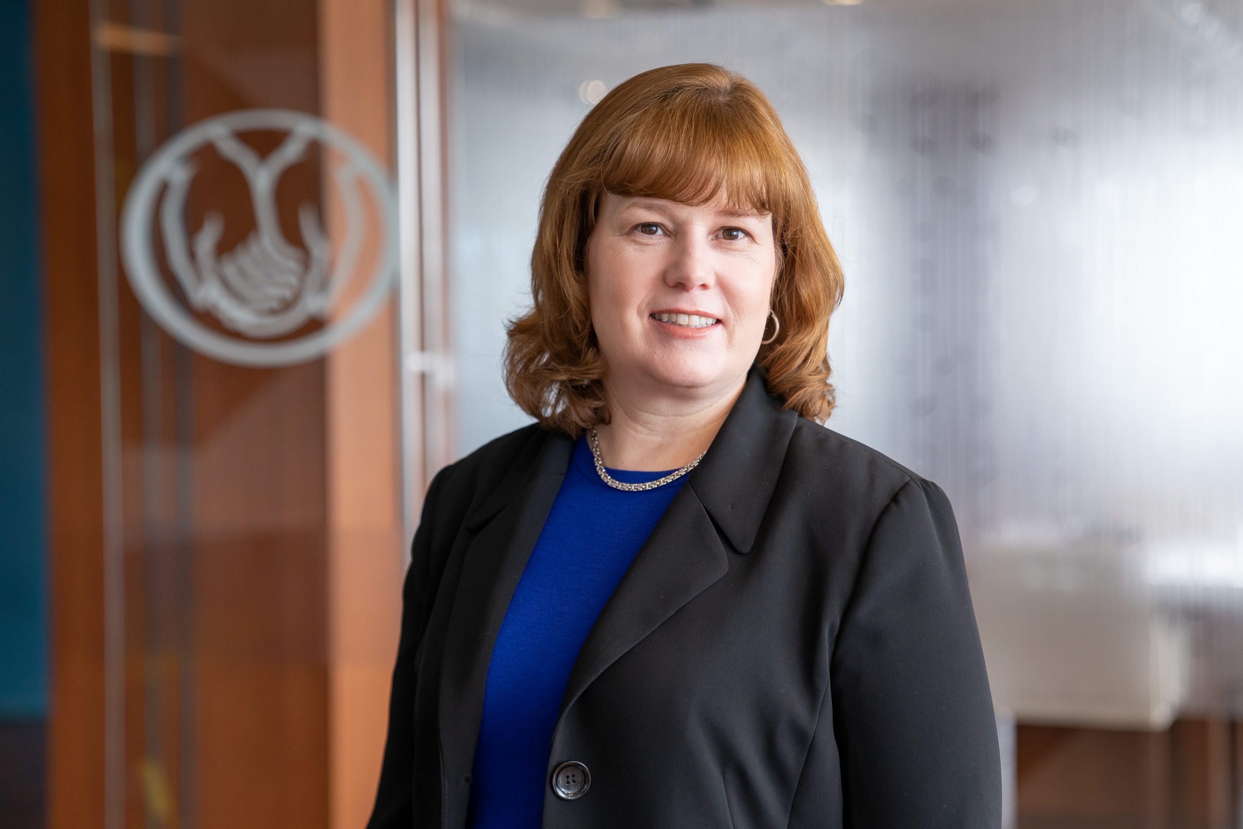 Portrait of Allstate CHRO Carrie Blair, who is wearing a black blazer over a blue blouse.