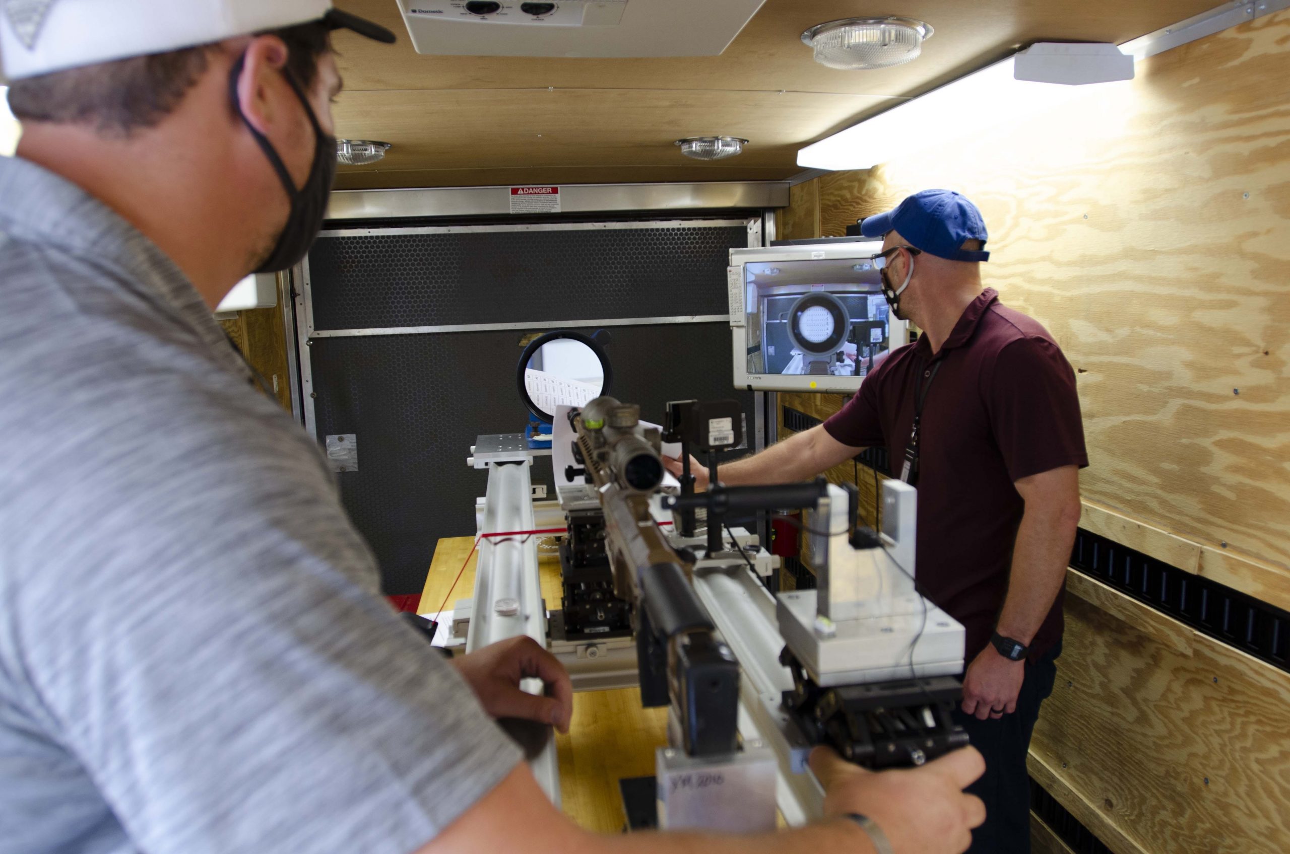 Technicians assigned to the Base and Test Support Services contractor conduct bore sight collimation on an MK-22 Precision Sniper Rifle (PSR) after a paratrooper airdrop.