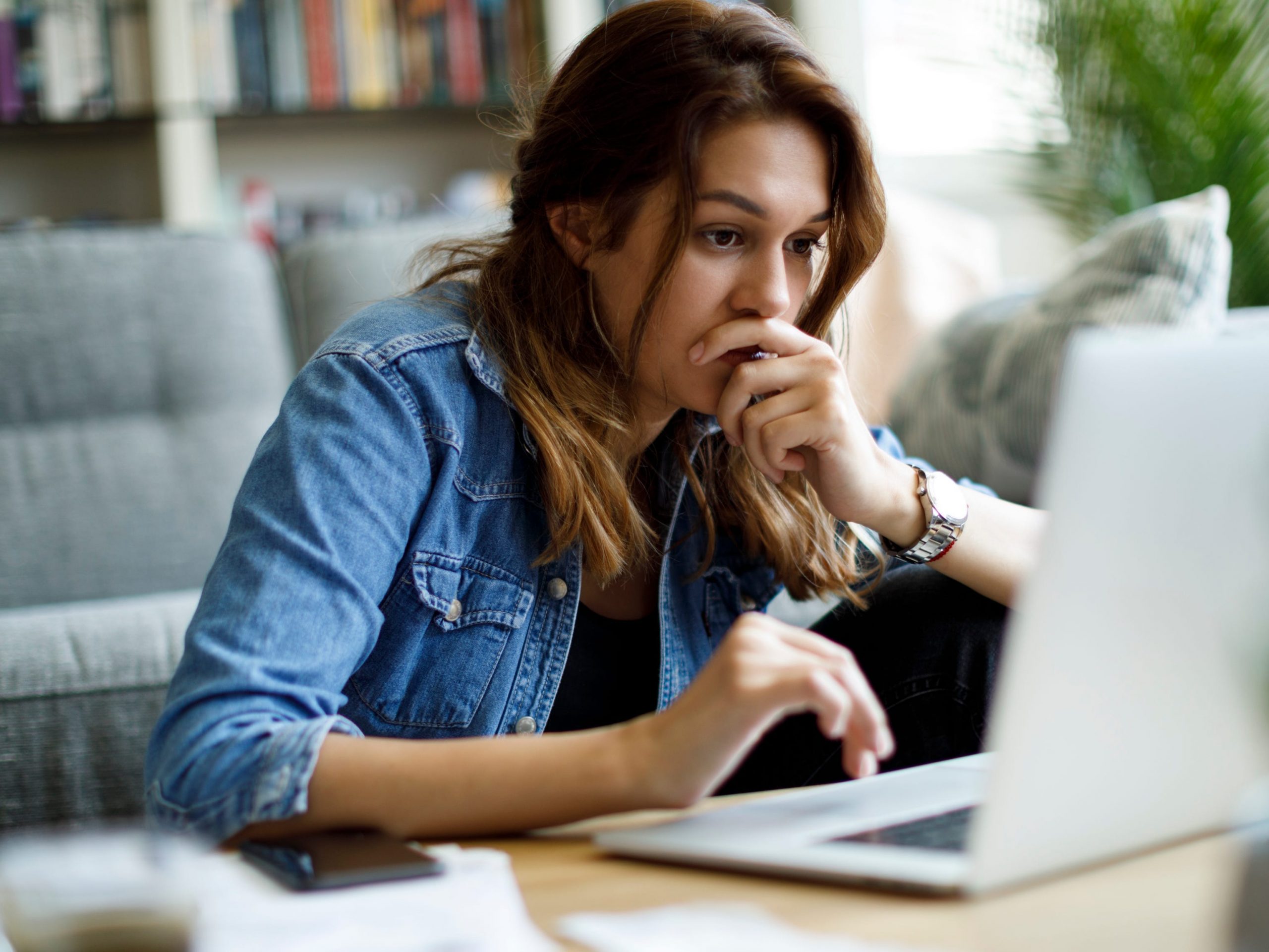 Worried young woman working at home upset work computer laptop