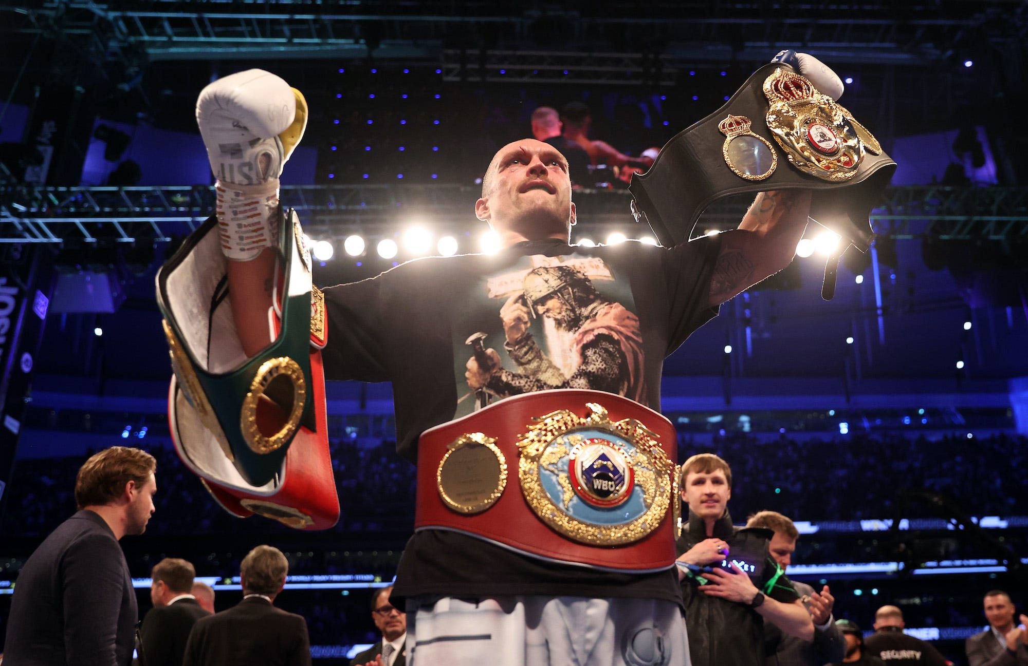 Oleksandr Usyk holds the world championship belts aloft.