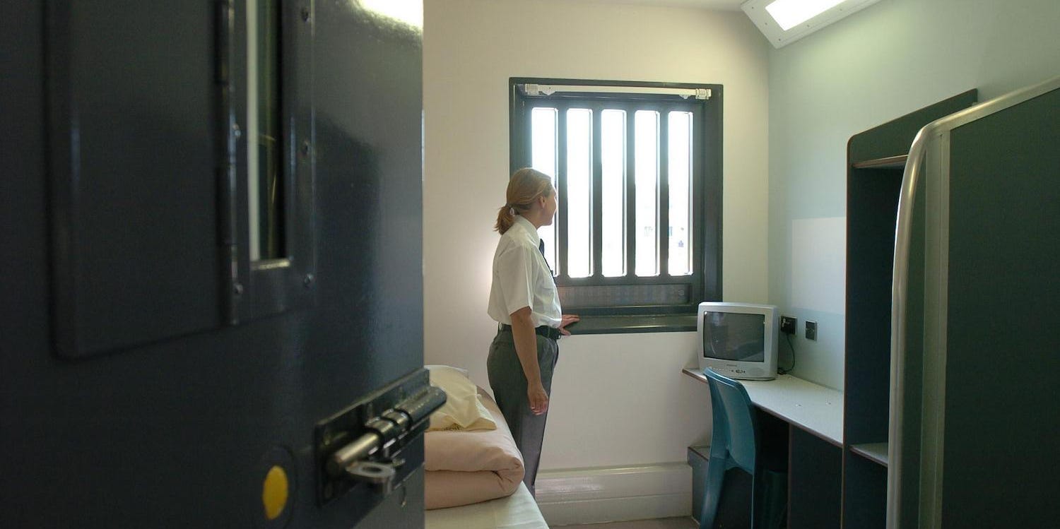 woman guard standing in prison cell HMP Bronzefield