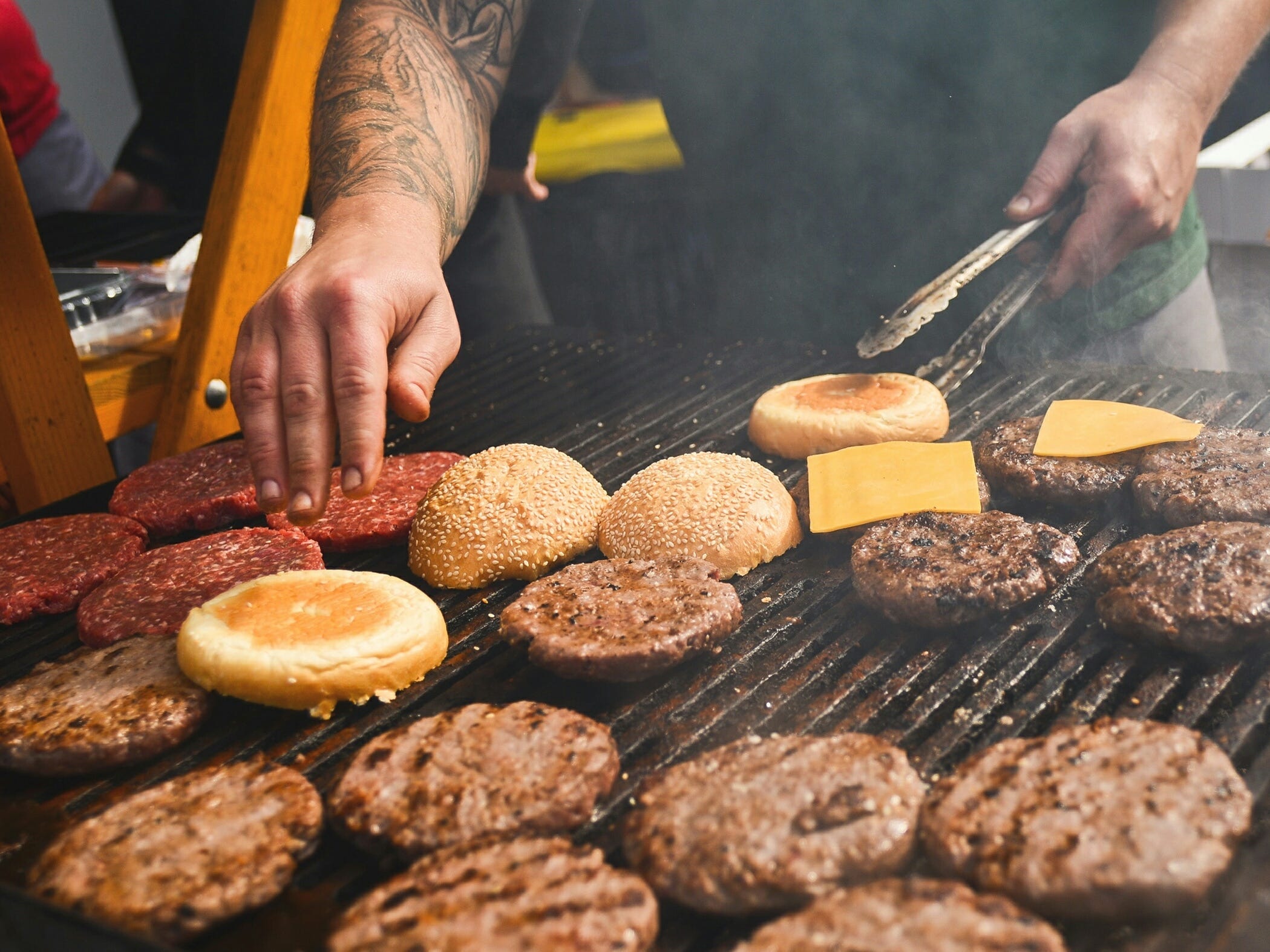 A man flips burgers on a grill