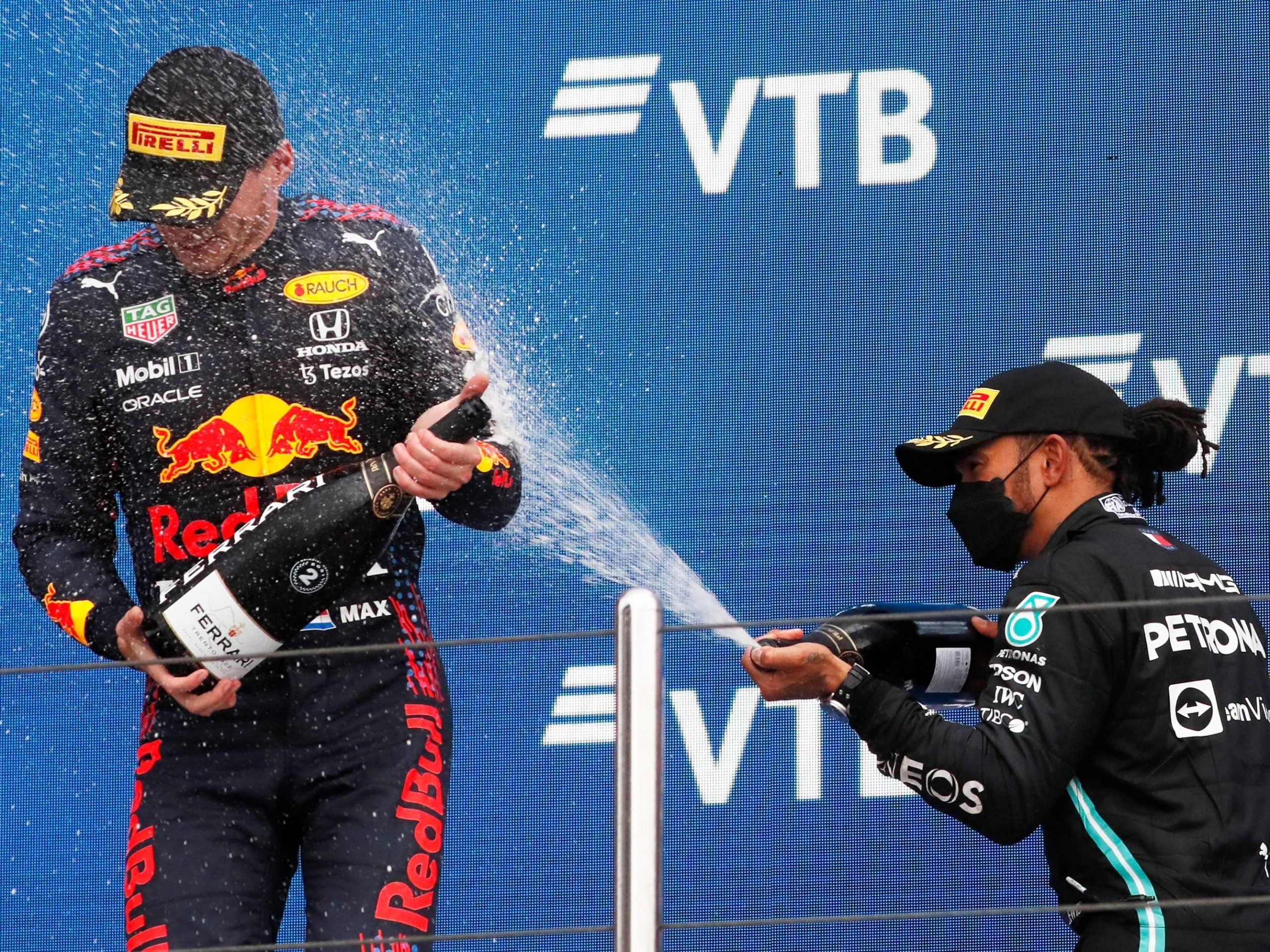 Max Verstappen is sprayed by champagne by Lewis Hamilton