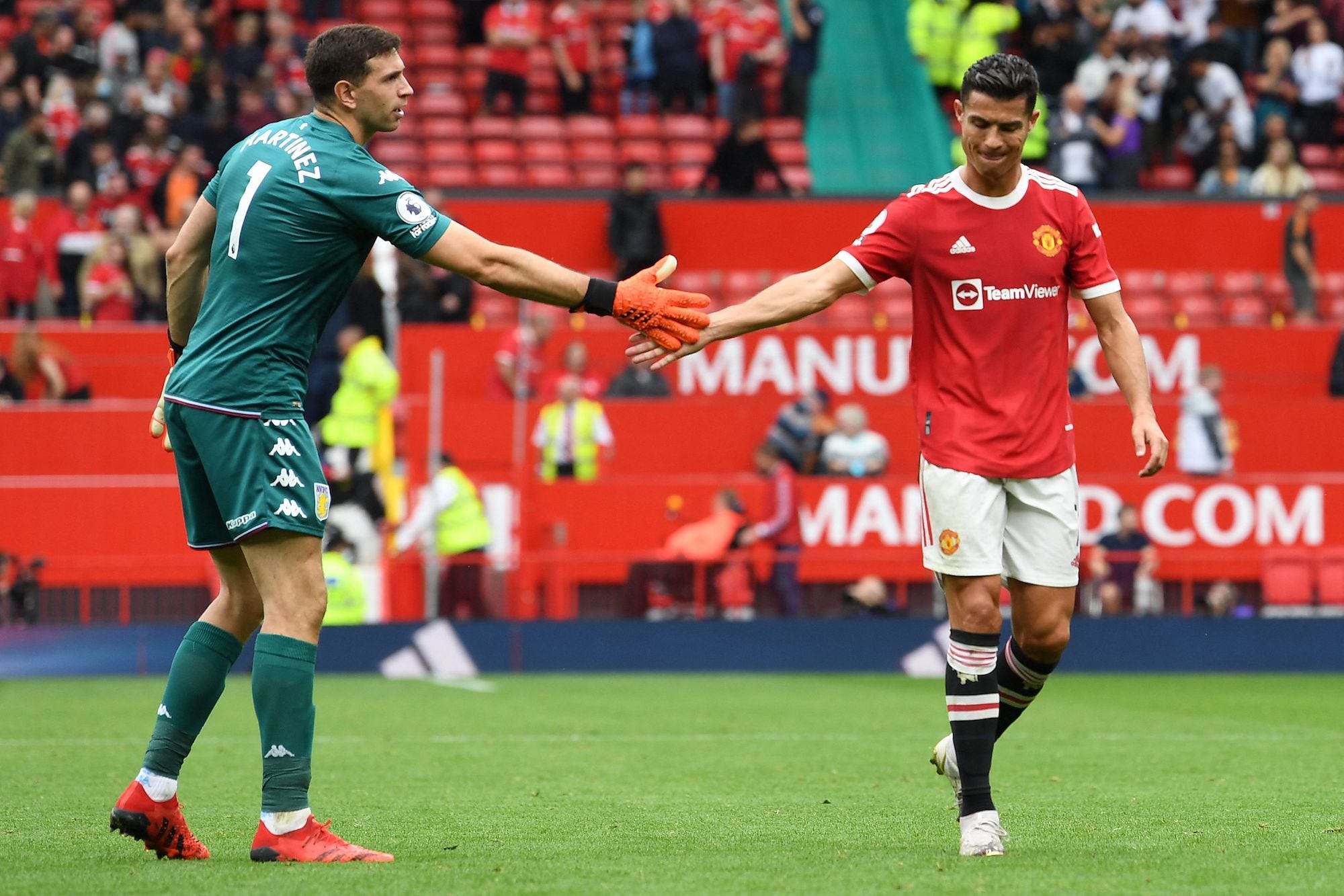 Aston Villa's Argentinian goalkeeper Emiliano Martinez (L) taps hands with Manchester United's Portuguese striker Cristiano Ronaldo after the English Premier League football match between Manchester United and Aston Villa at Old Trafford