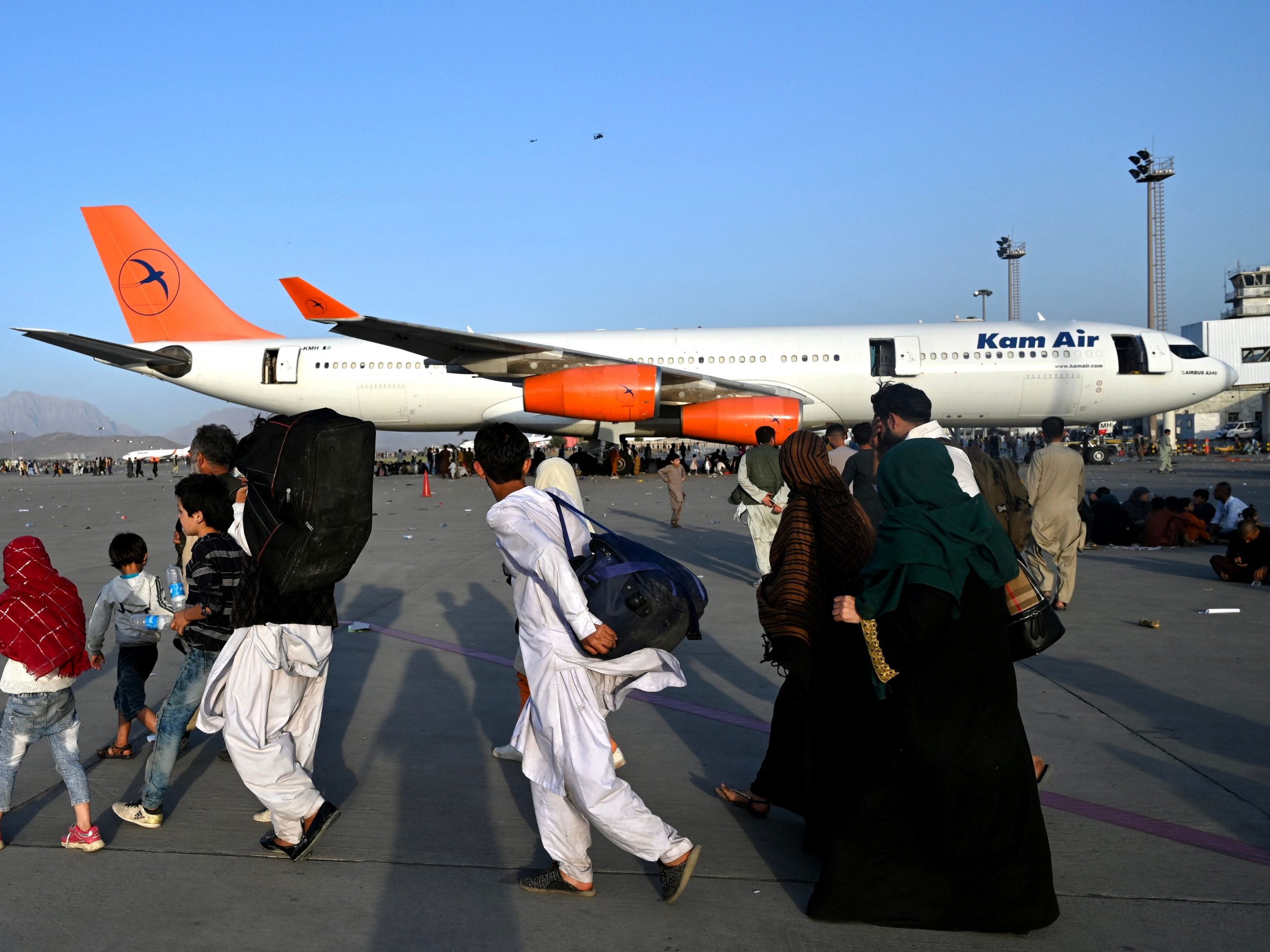 Afghan families walks by plane at kabul airport in afghanistan