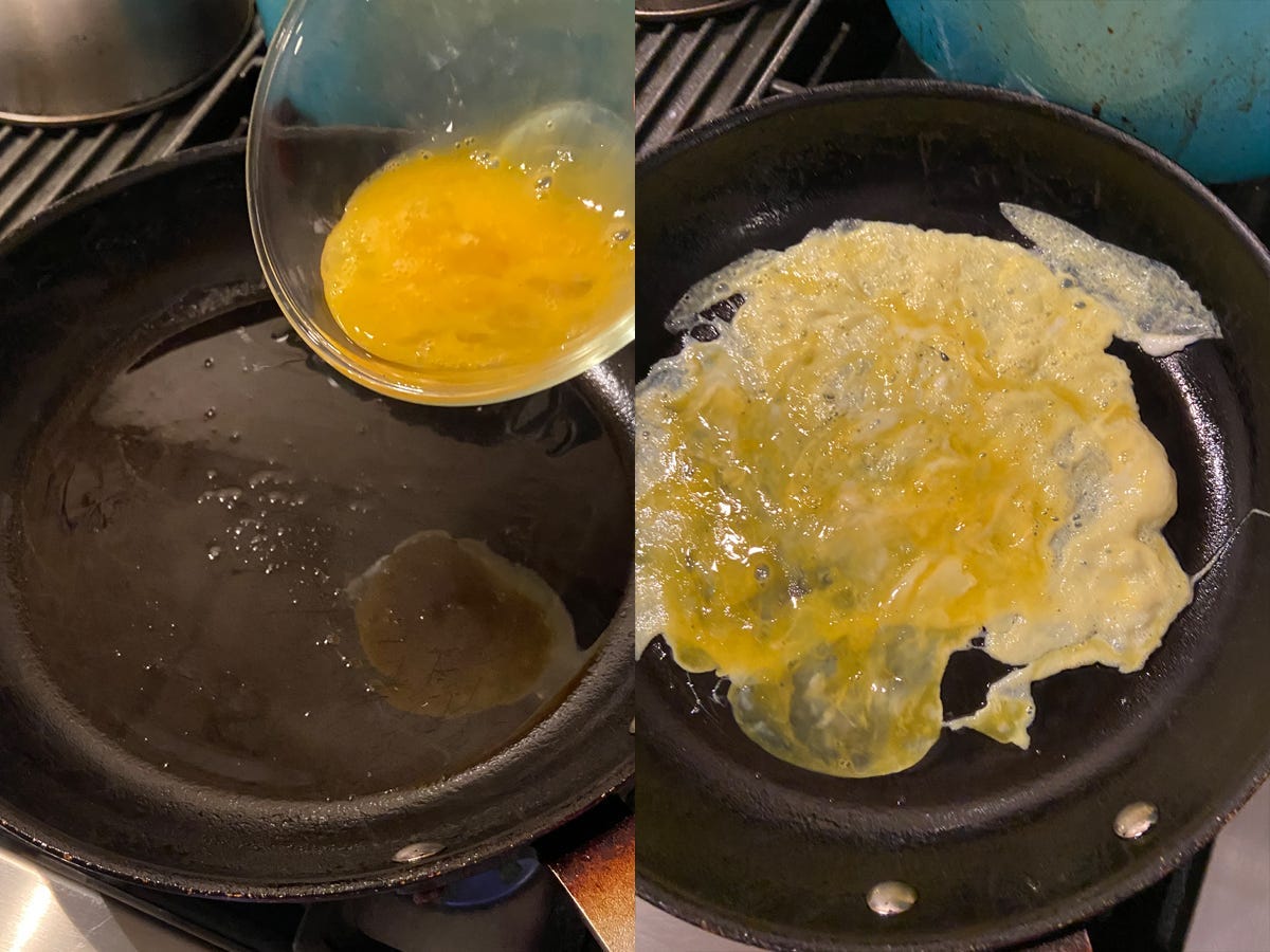 Scrambled eggs in a pan, spread out thinly.