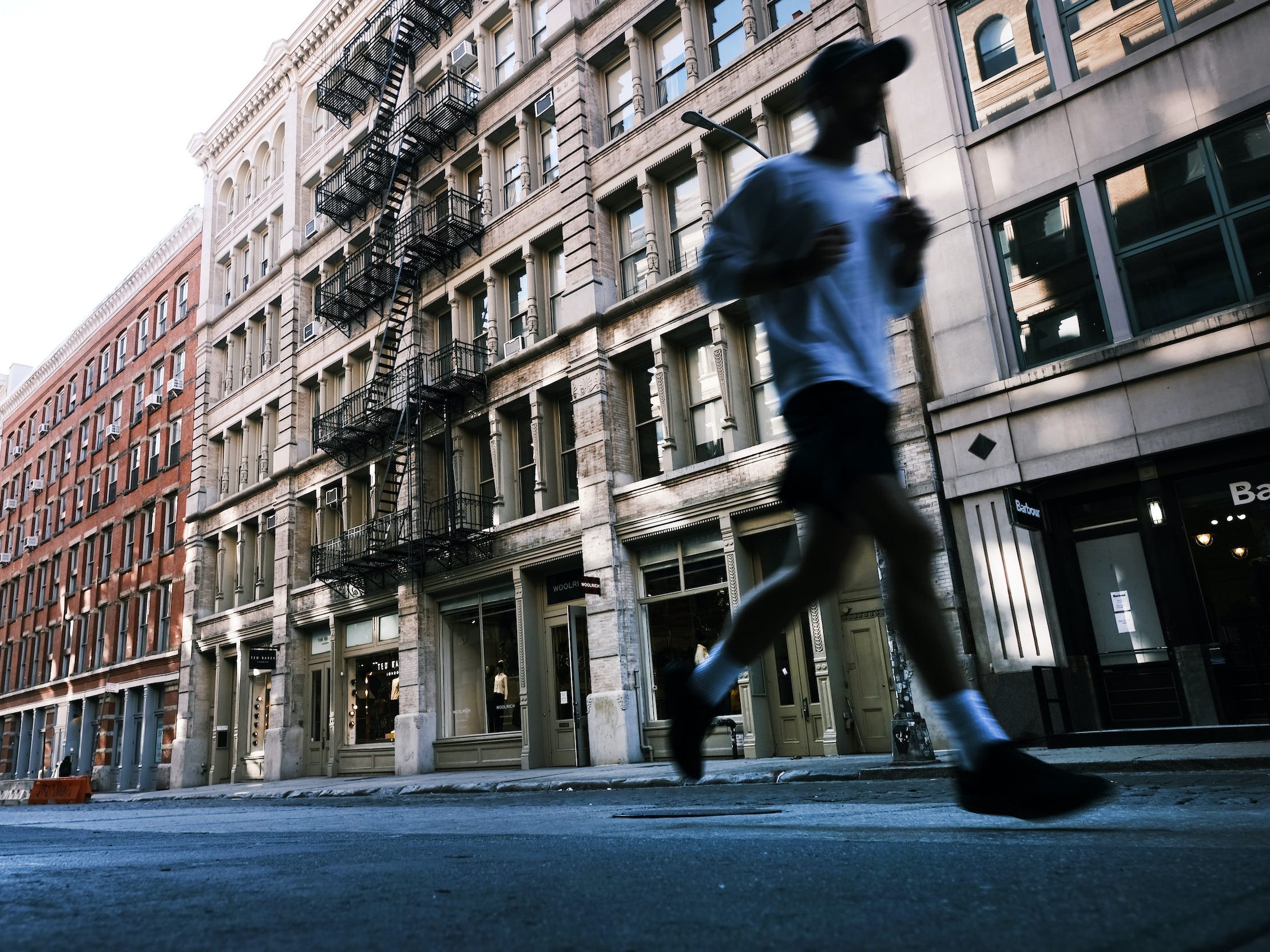 Many running through New York City's SoHo neighborhood with apartment buildings in background