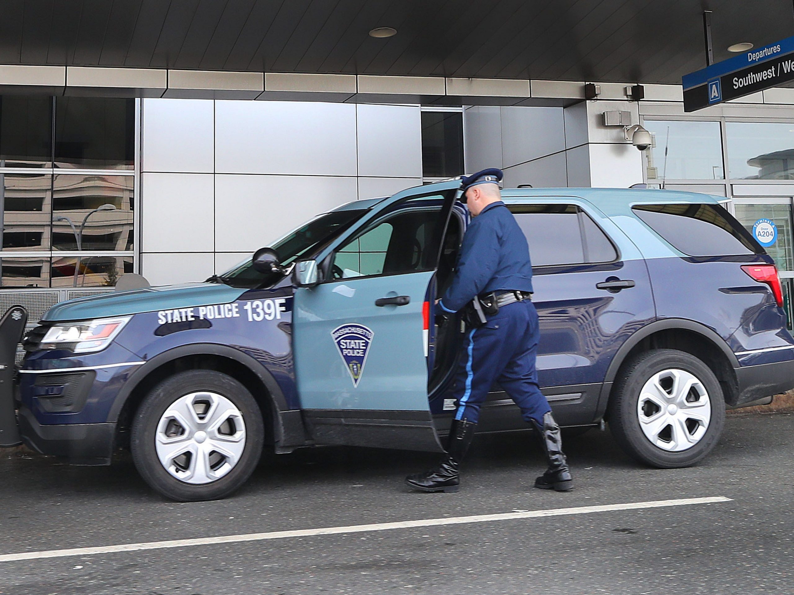 A Massachusetts State Police trooper gets into a Troop F SUV in front of Terminal A at Logan Airport in Boston on March 23, 2018.