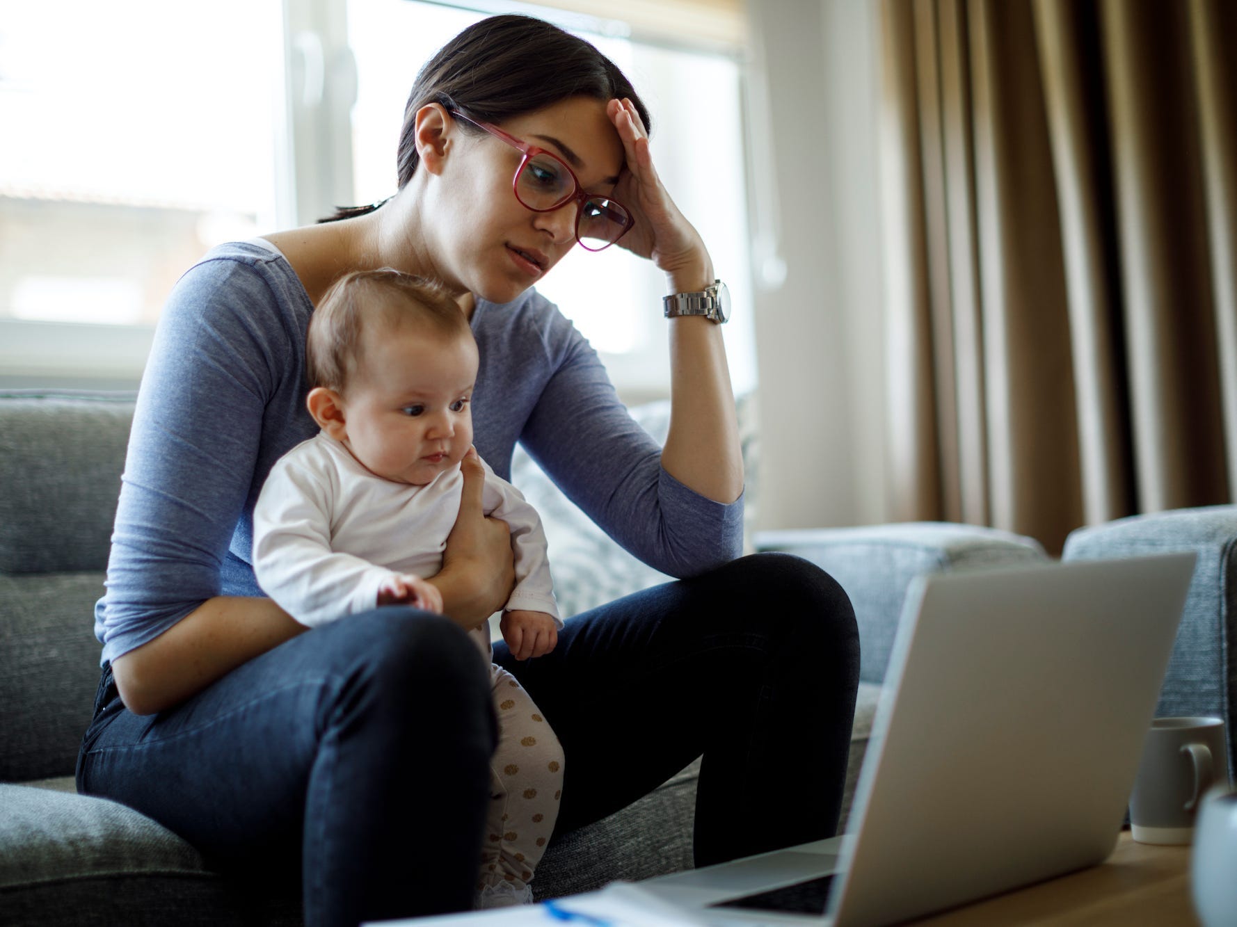 mom working from home while holding her child