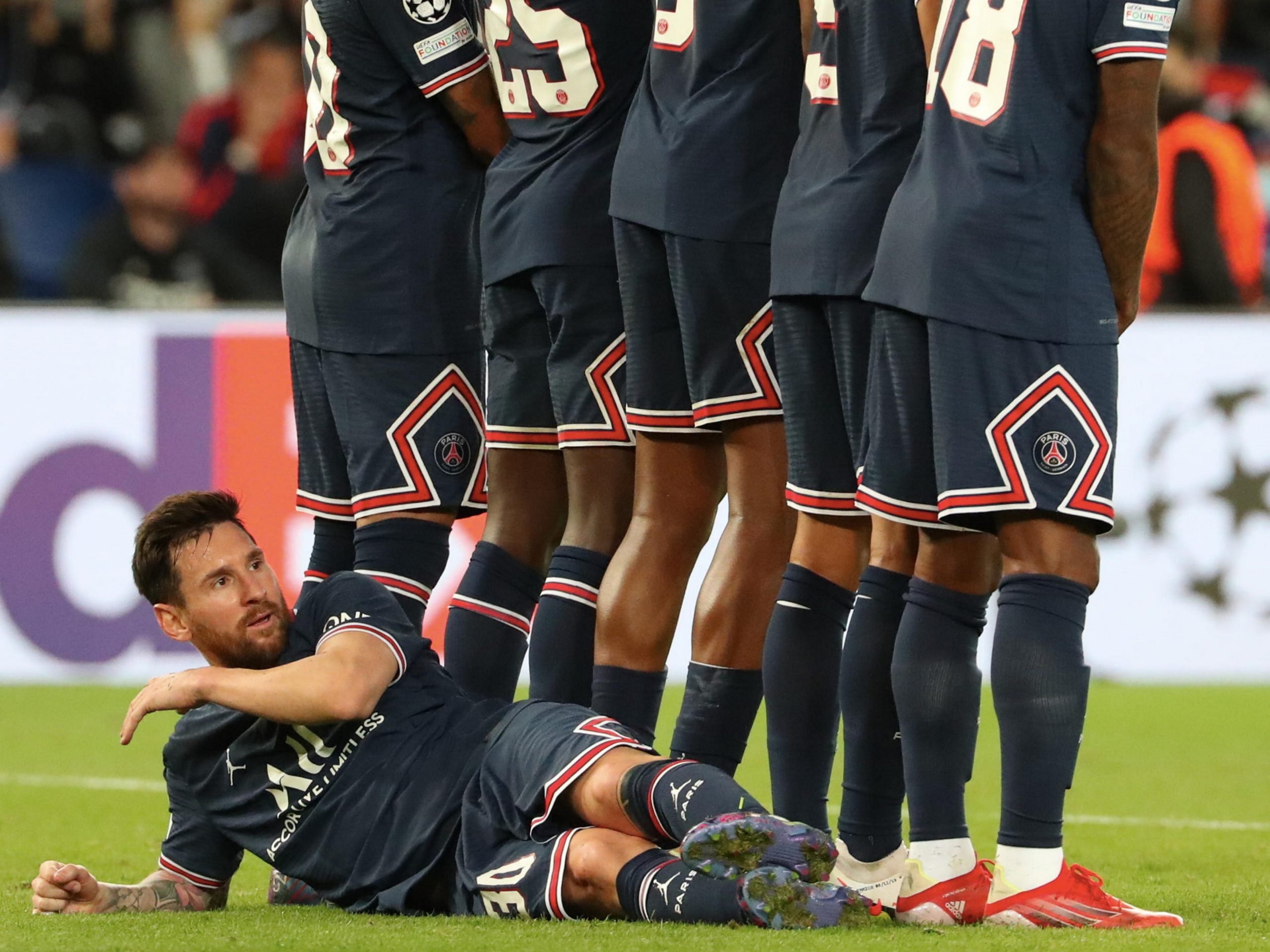 Lionel Messi lies down behind his PSG teammates during its Champions League clash against Manchester City