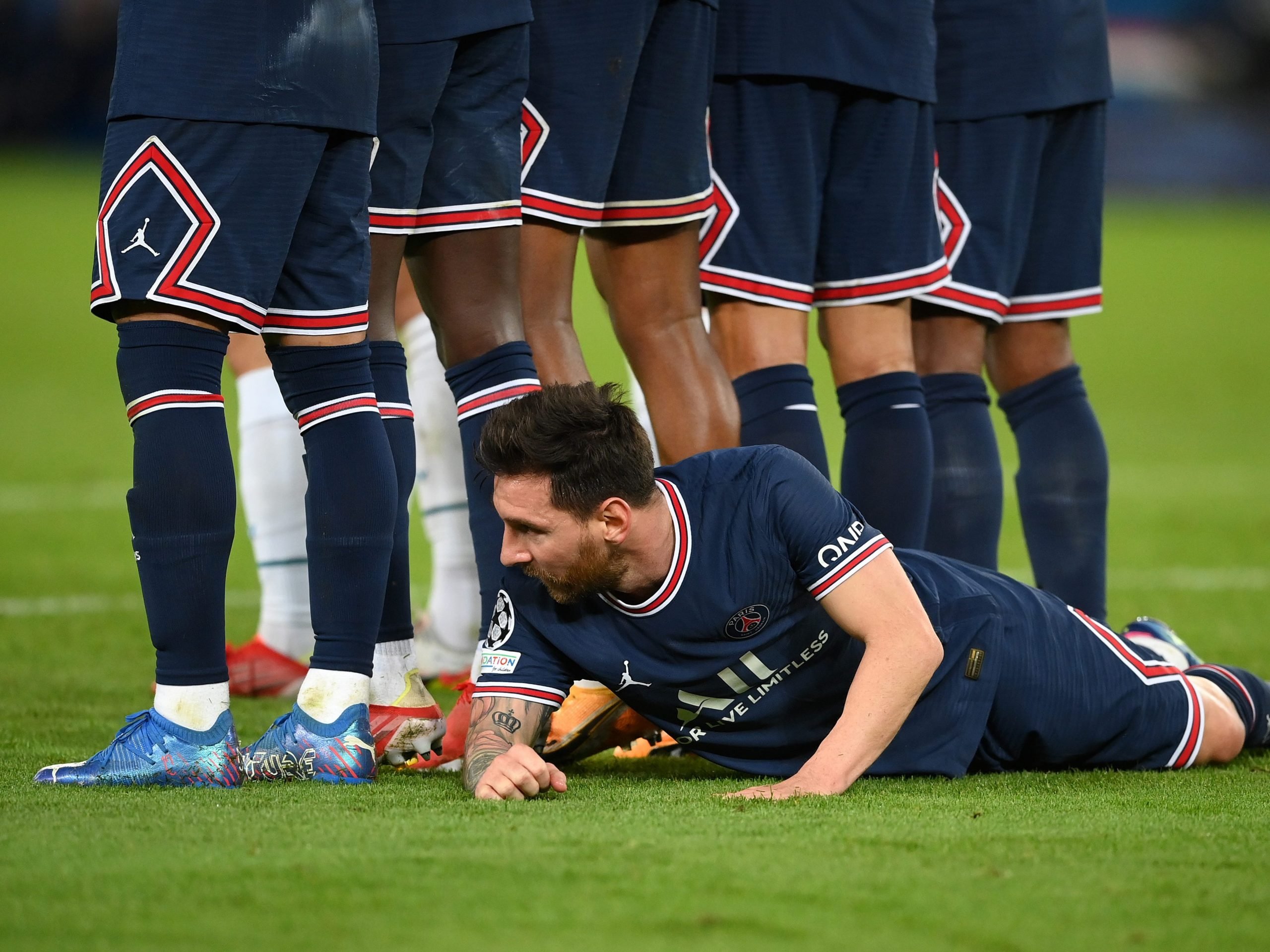 Lionel Messi of Paris Saint-Germain lies behind the Paris Saint-Germain wall as they defend a free kick