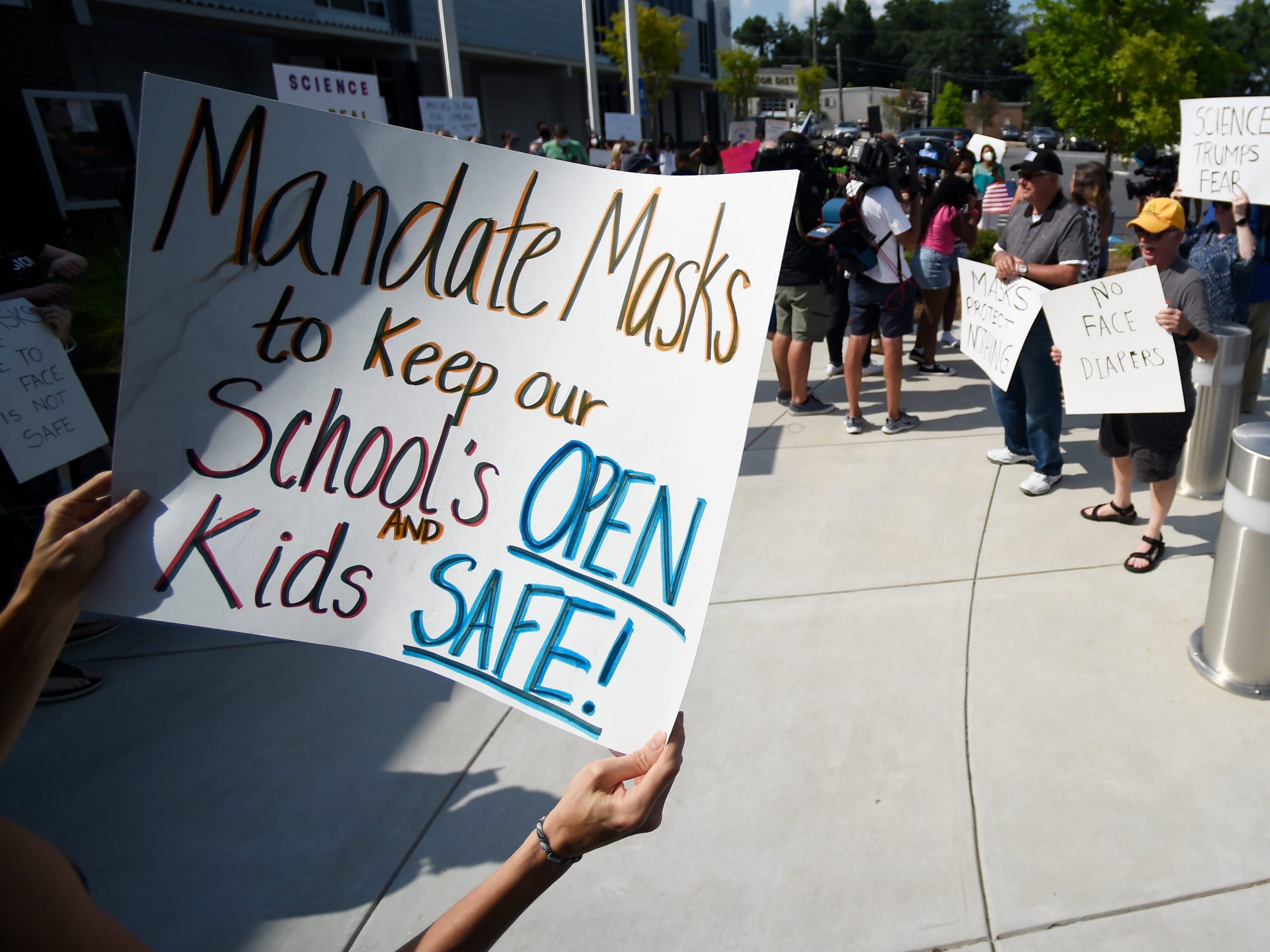 A pro-mask sign is seen as demonstrators face off at the Cobb County School Board Headquarters Thursday, Aug. 12, 2021, in Marietta, Ga.