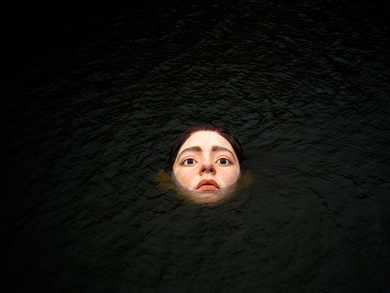 A fiberglass sculpture entitled "Bihar" ("Tomorrow" in Basque), by Mexican hyperrealist artist Ruben Orozco, is submerged in the Nervion river in Bilbao, Spain, September 27, 2021.