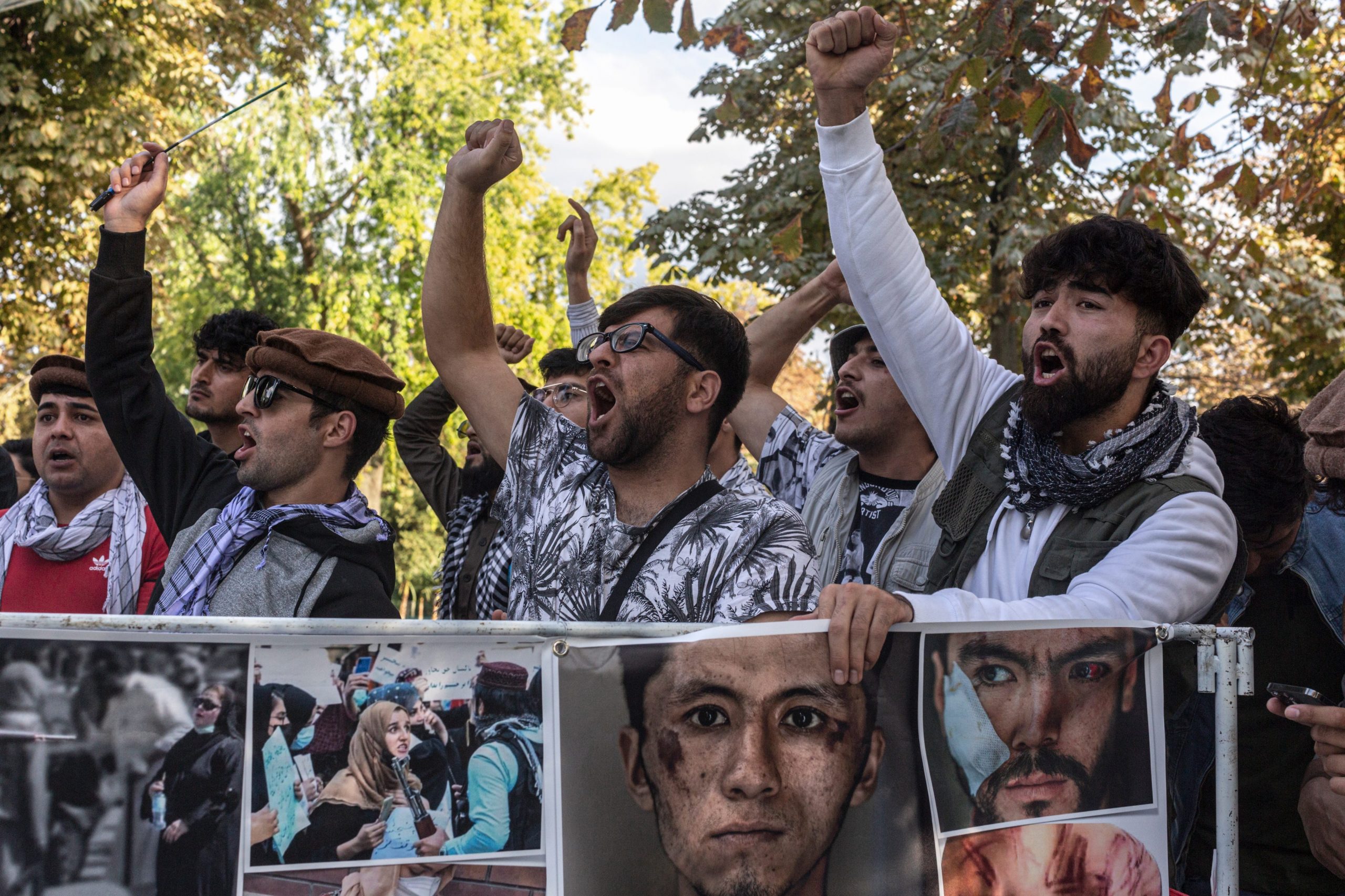 Men shout anti-taliban slogans as they hold images of journalists beaten by the group and women threatened at recent protests in Kabul during a ceremony marking the 20th anniversary of the death of Ahmad Shah Massoud, an Afghan politician, military leader and icon of resistance against the Taliban and Al Qaeda, on September 12, 2021 in Paris, France.