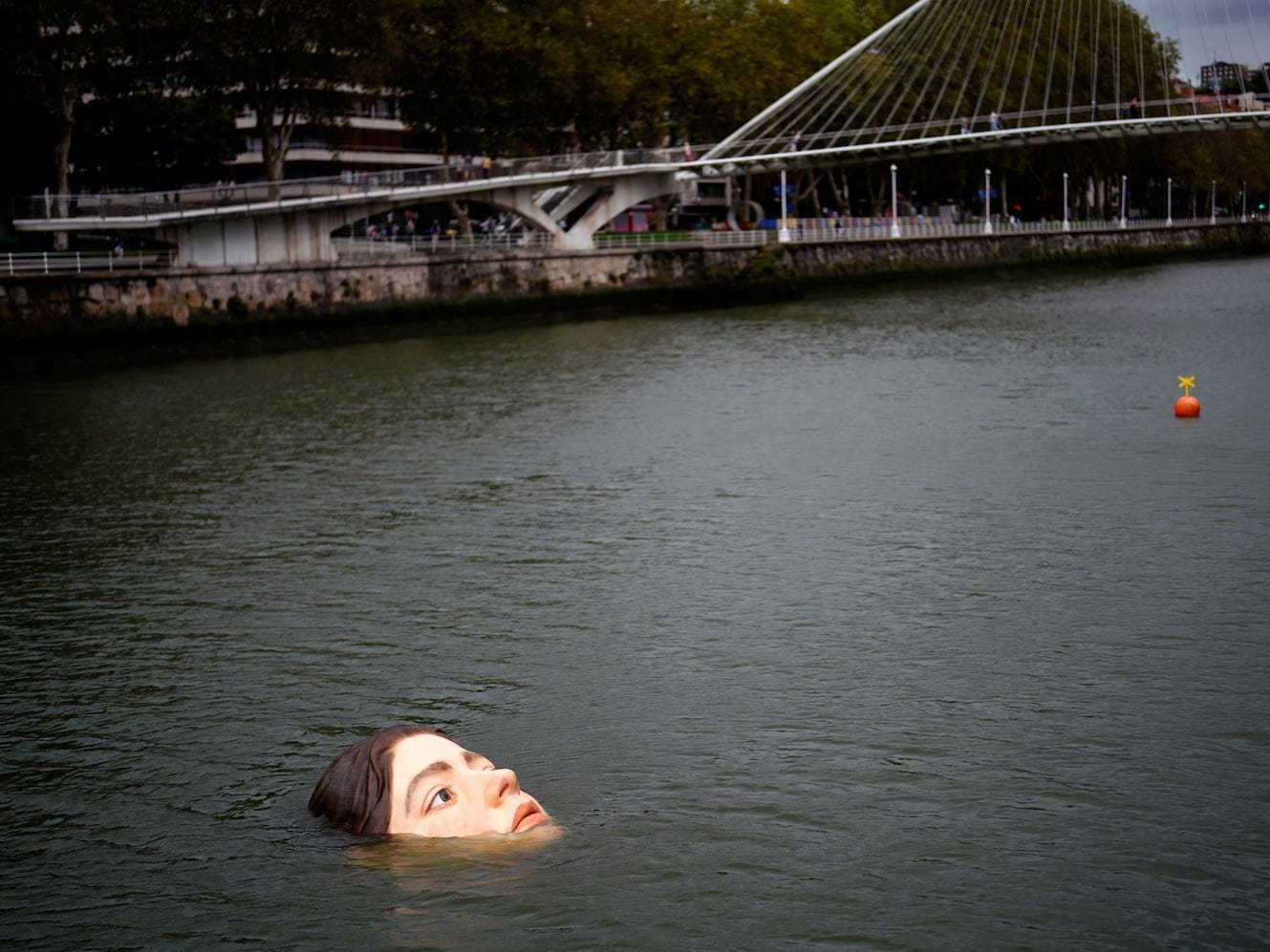 A fiberglass sculpture entitled "Bihar" ("Tomorrow" in Basque), by Mexican hyperrealist artist Ruben Orozco, is submerged in the Nervion river in Bilbao, Spain, September 27, 2021.