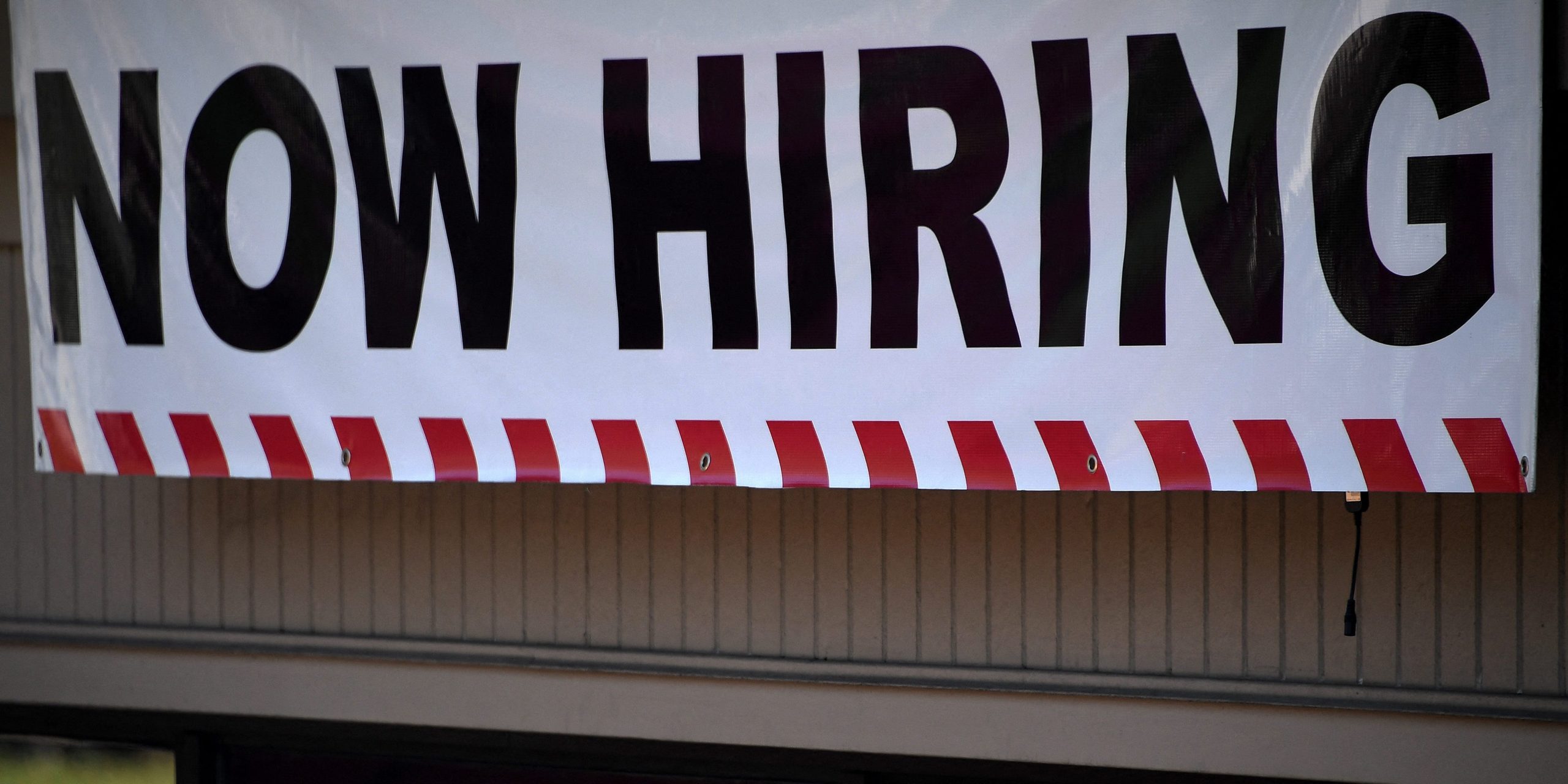 A "Now Hiring" sign stands outside a restaurant in Arlington, Virginia, on August 12, 2021.